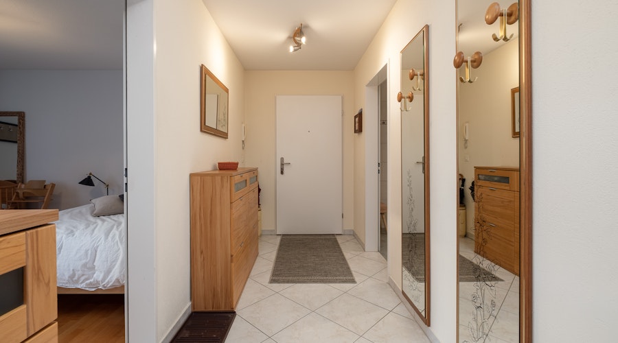 Heller Flur mit Spiegeln und Holzkommode