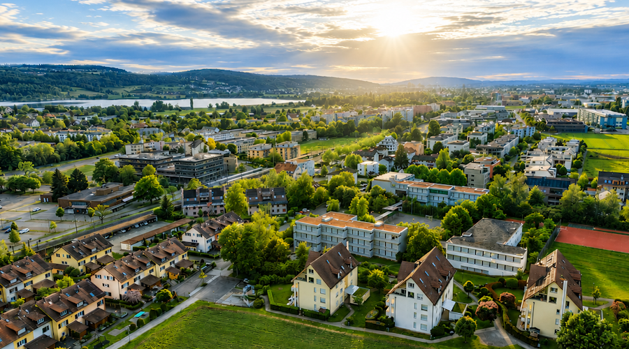 Luftaufnahme eines grünen Wohngebiets im Abendlicht