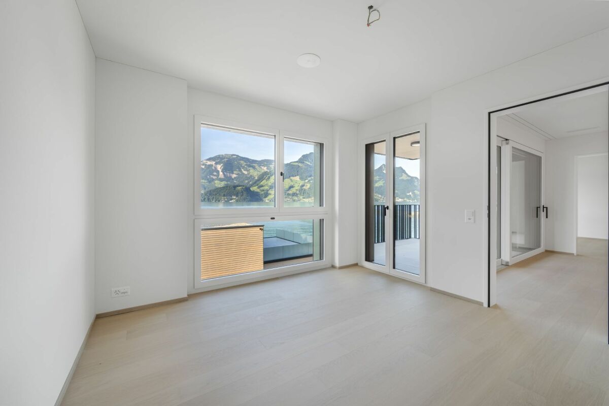 Helles, leeres Schlafzimmer mit Bergblick und Balkonzugang