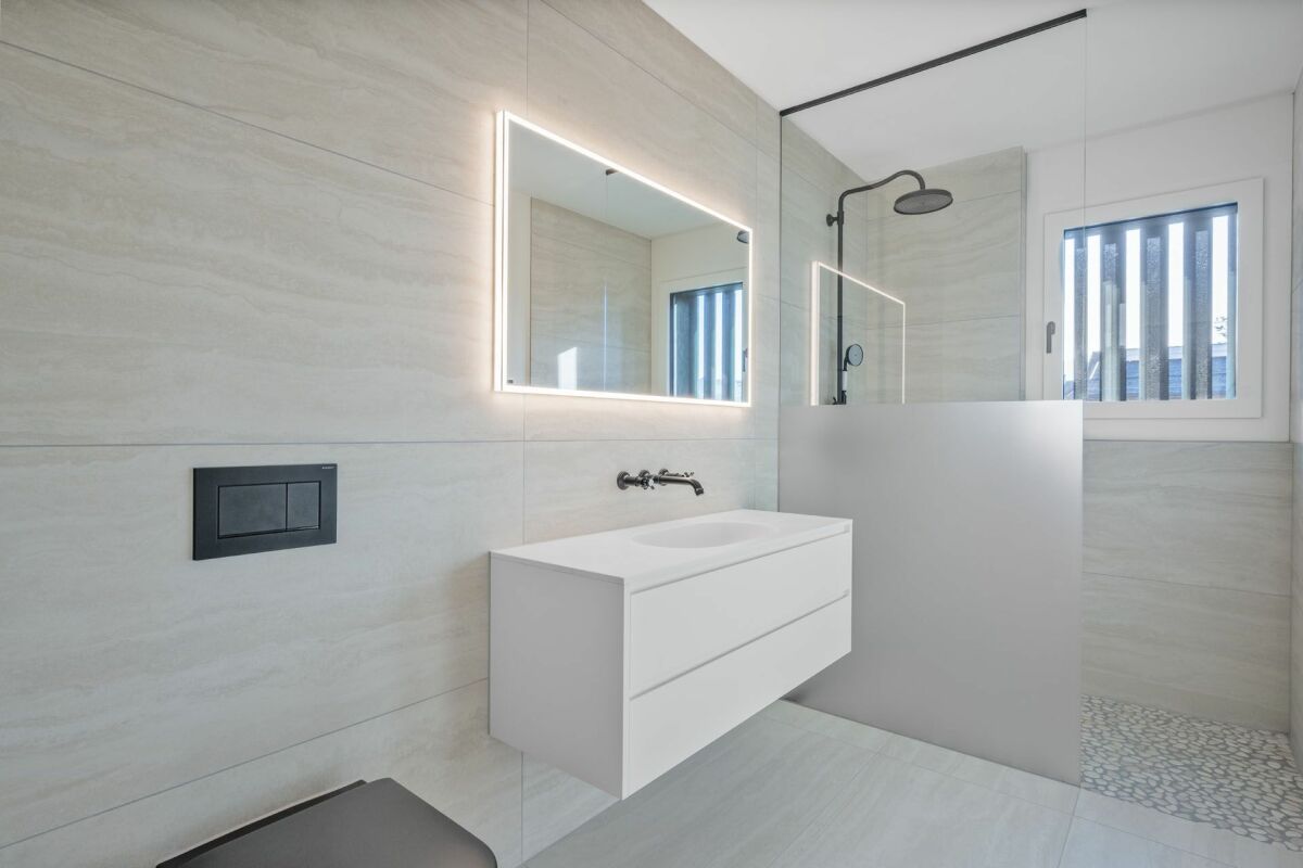 Modernes Badezimmer mit Glasdusche und LED-Spiegel