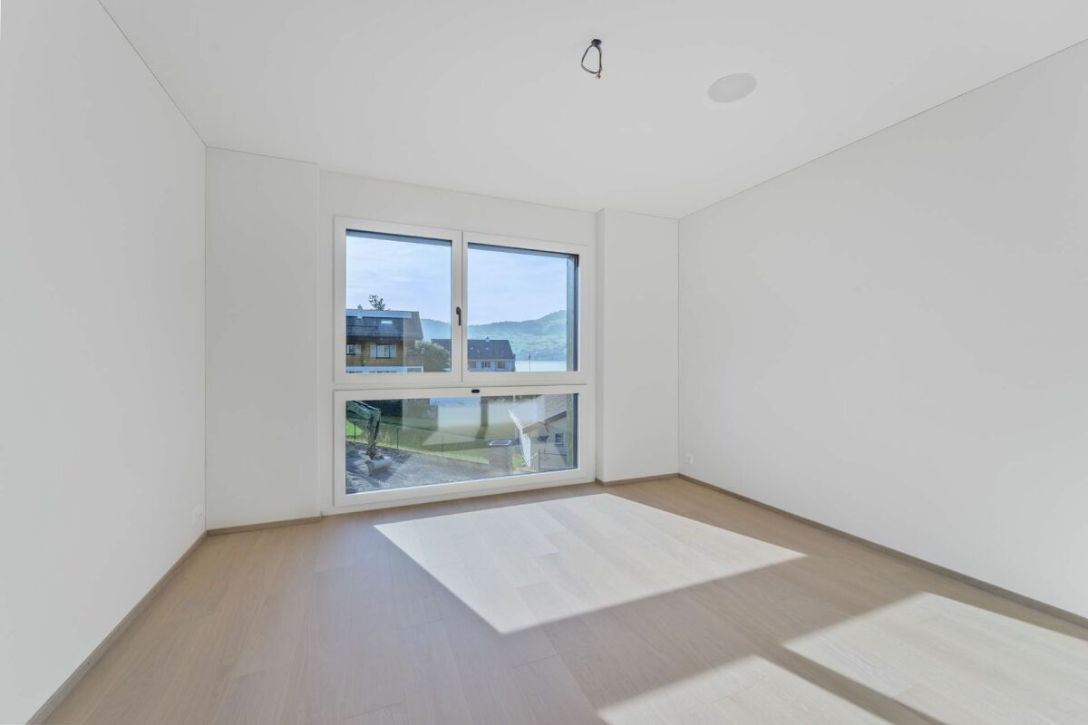 Leerer heller Raum mit großem Fenster und Seeblick