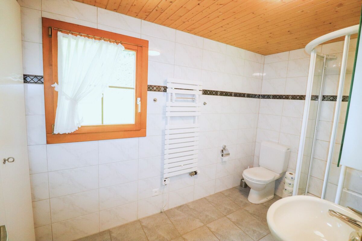 Helles Badezimmer mit Holzdecke und Fenster