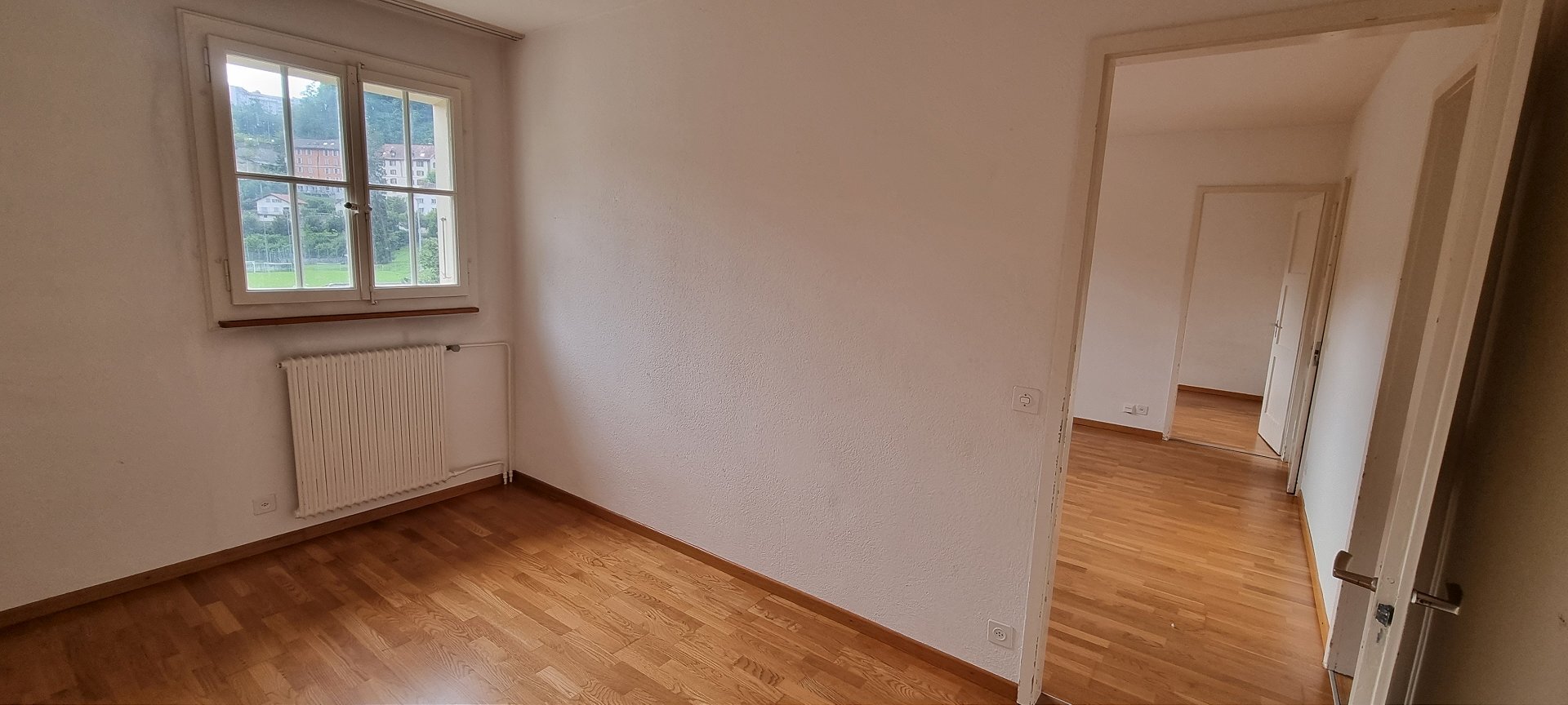 Leeres Zimmer mit Parkett und Fensterblick