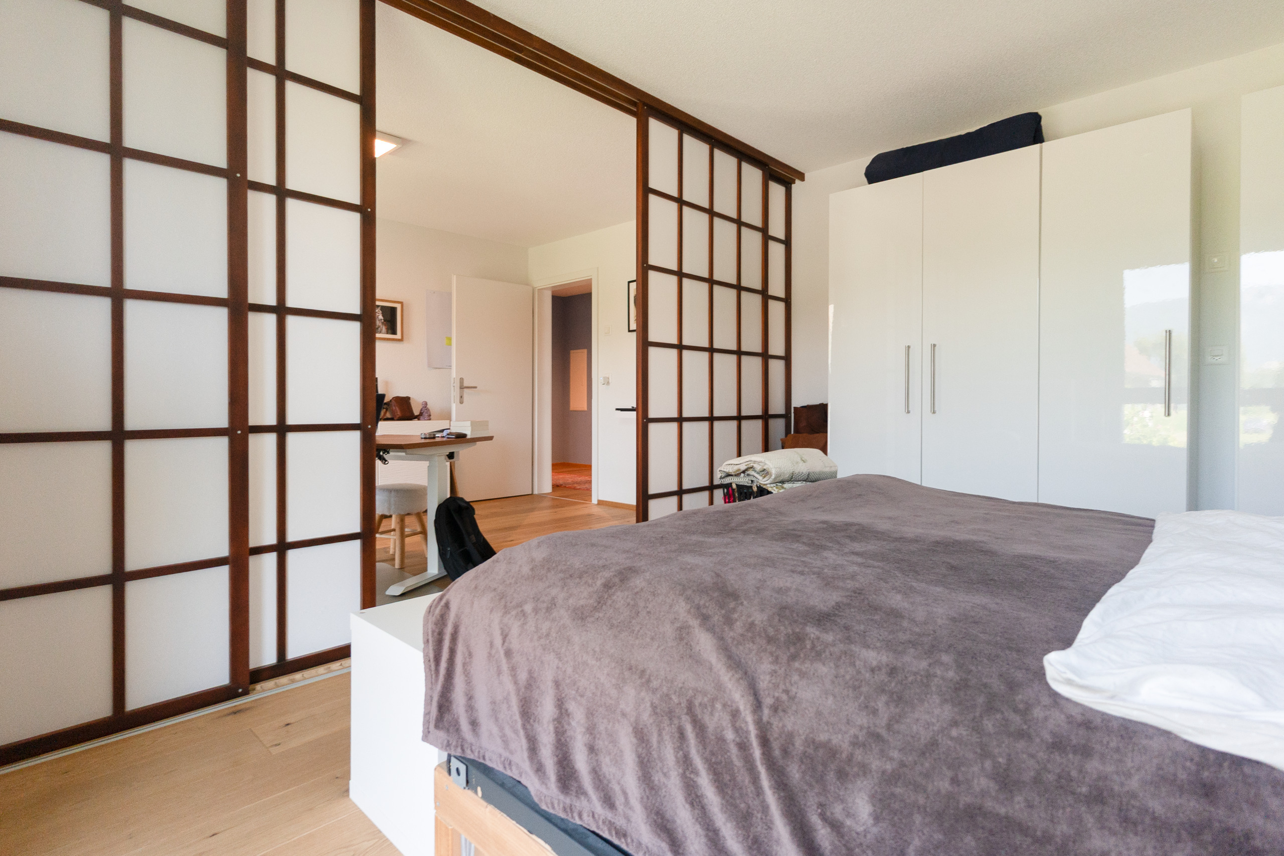 Modernes Schlafzimmer mit japanisch anmutender Schiebetrennwand
