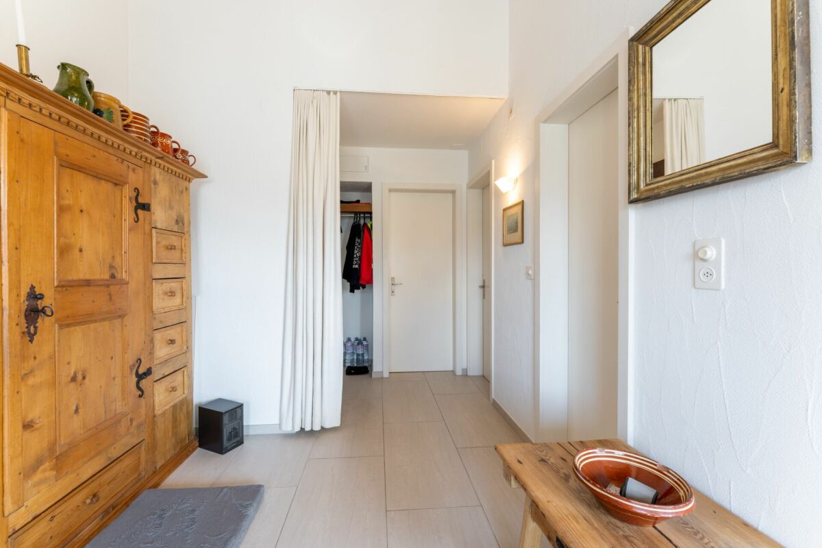 Heller Flur mit Holzschrank und Zugang zu mehreren Türen