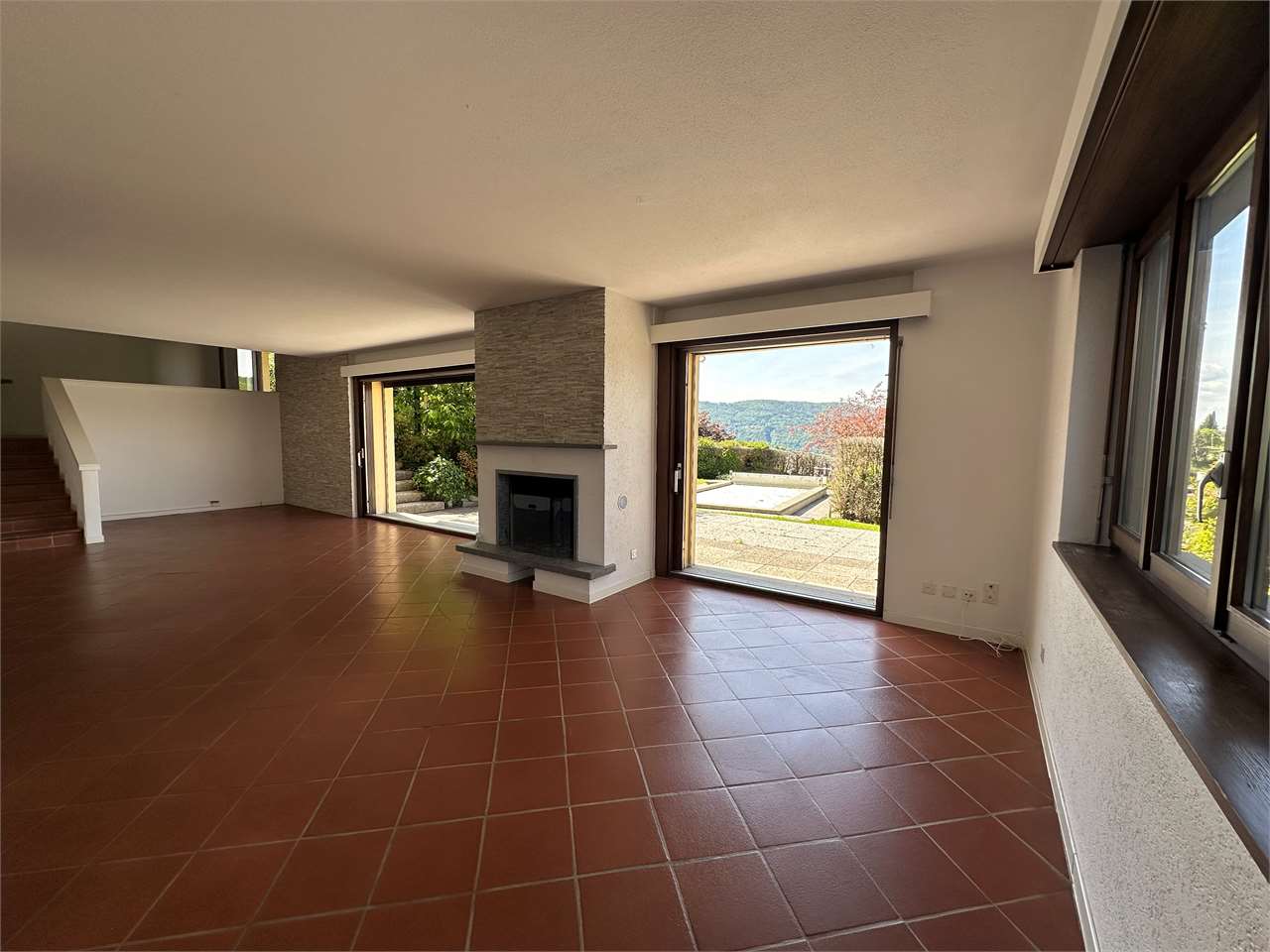 Wohnzimmer mit Kamin und Terrassenausgang