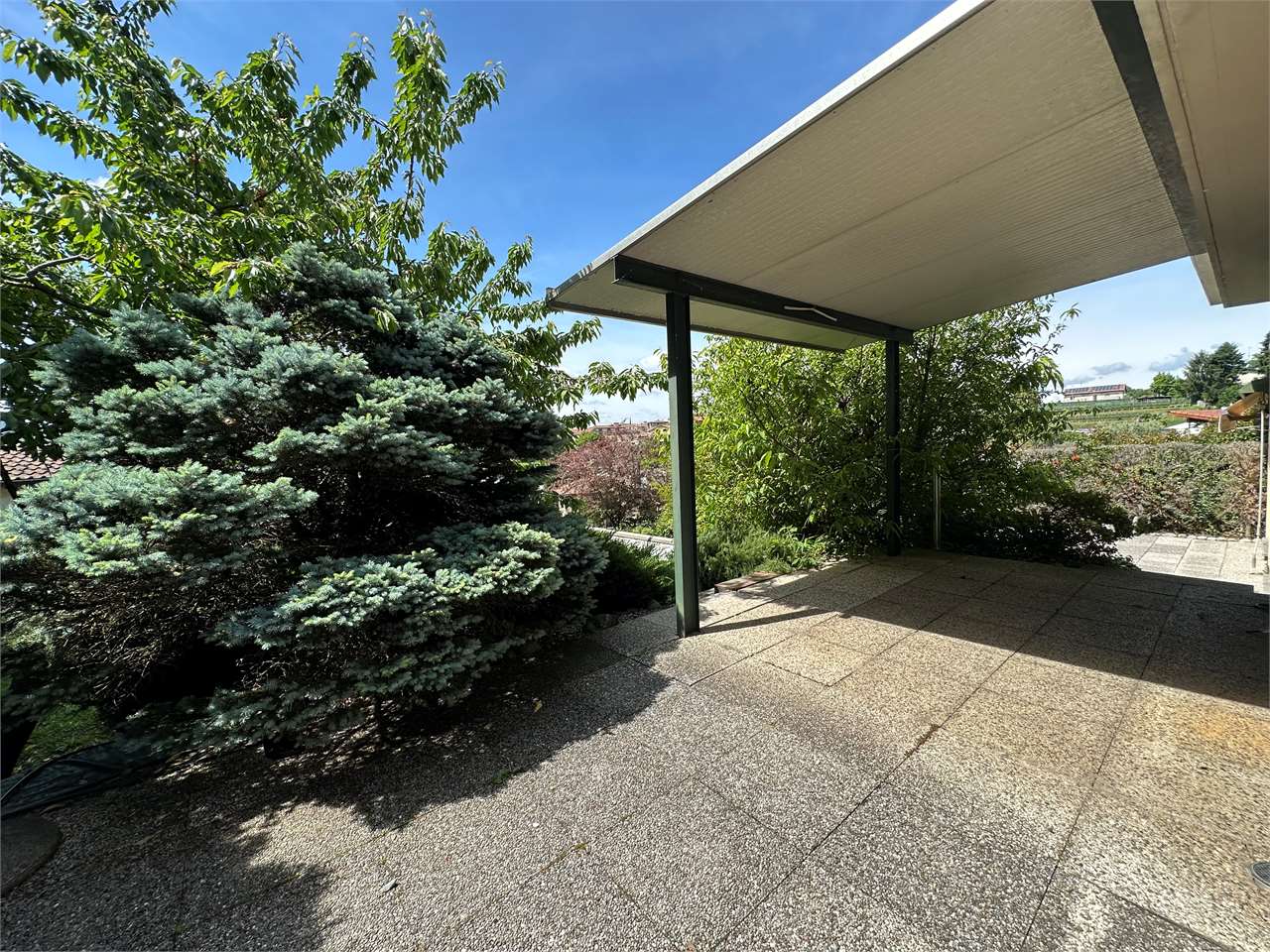 Überdachte Terrasse mit Gartenblick