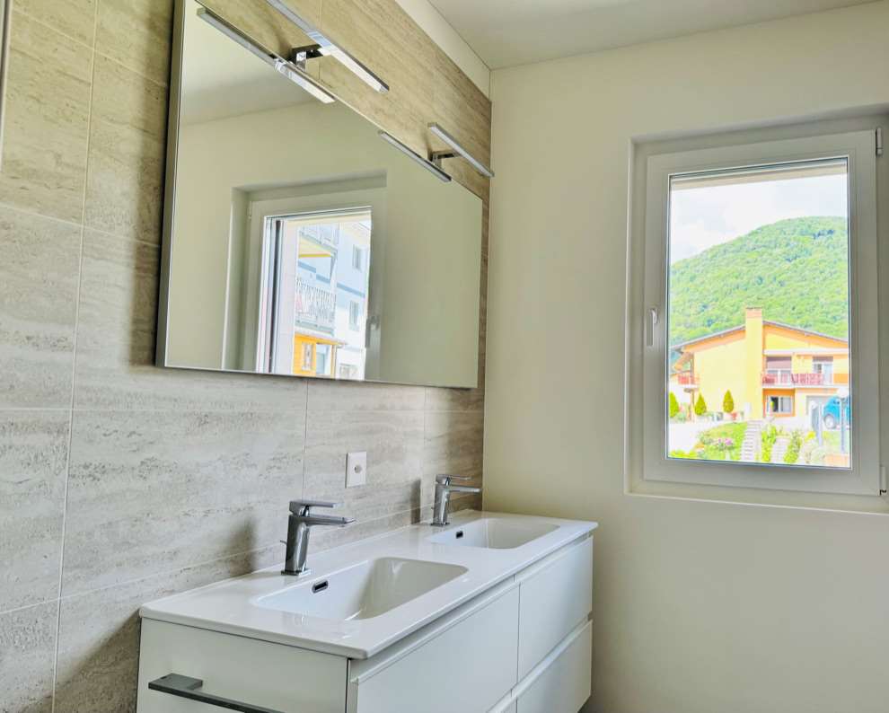 Modernes Badezimmer mit Doppelwaschtisch und Fensterblick