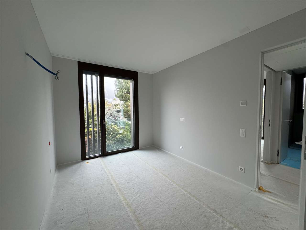 Unfertiger heller Raum mit Fenster und Türöffnung
