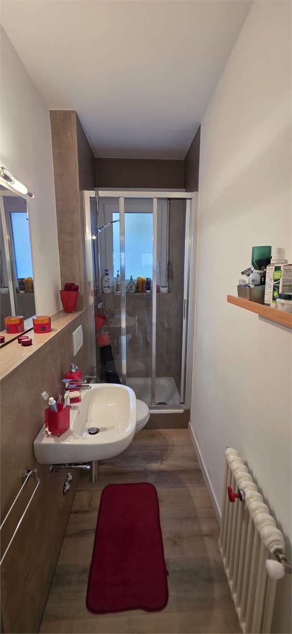 Schmales Badezimmer mit Dusche und Waschbecken