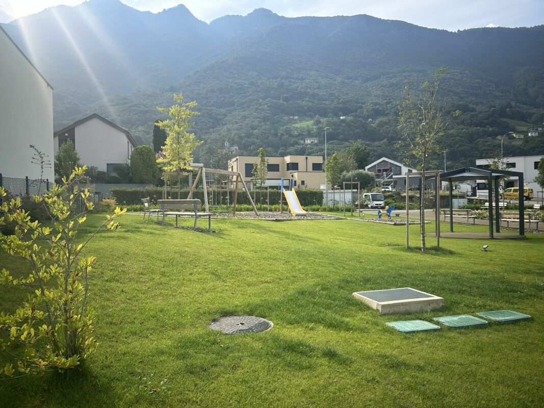 Wohnanlage mit Spielplatz und Bergkulisse