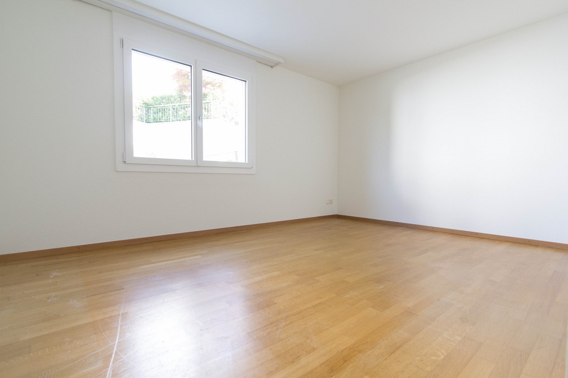 Leeres helles Zimmer mit Parkettboden