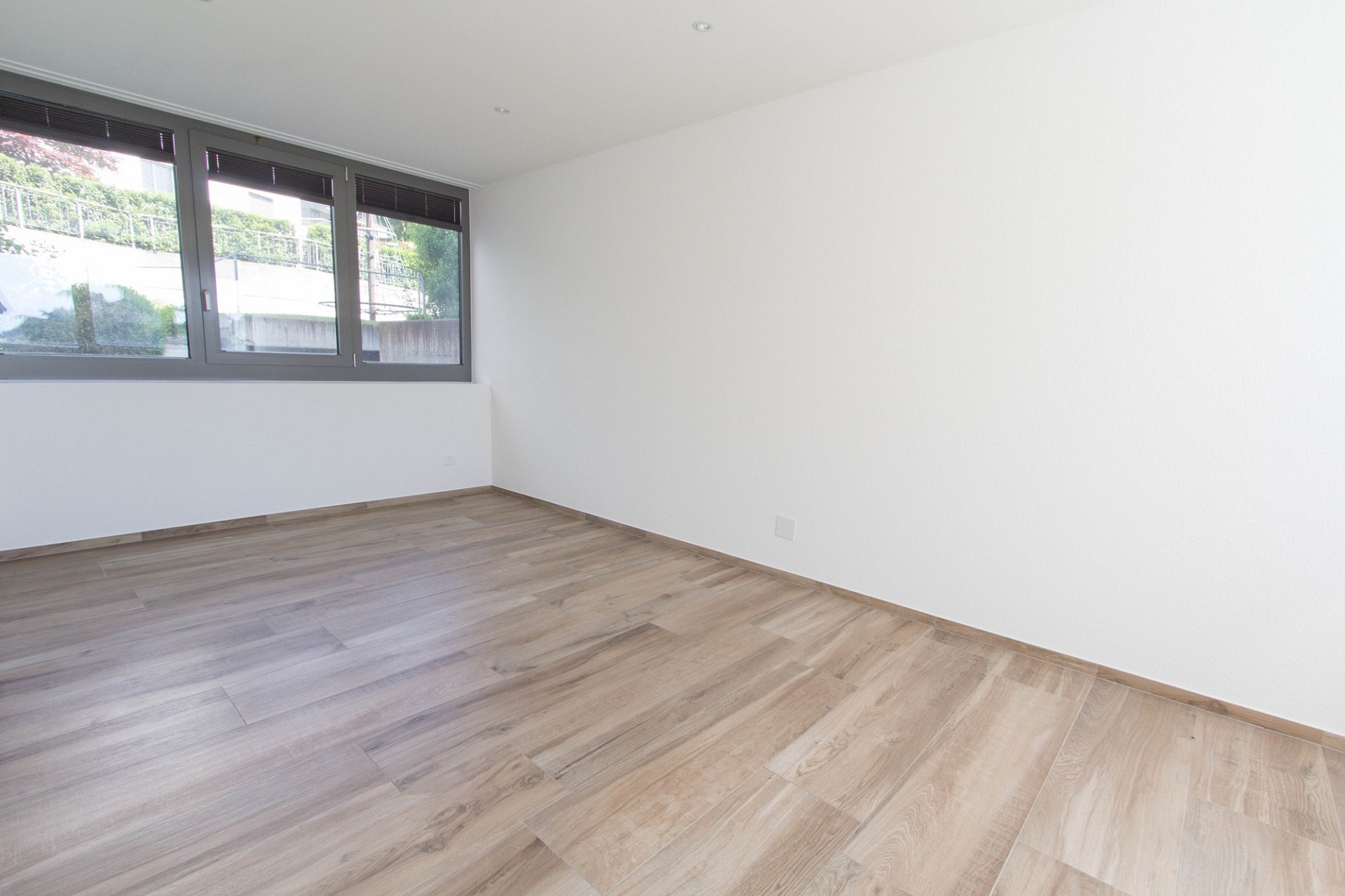 Helles, leeres Zimmer mit großem Fenster