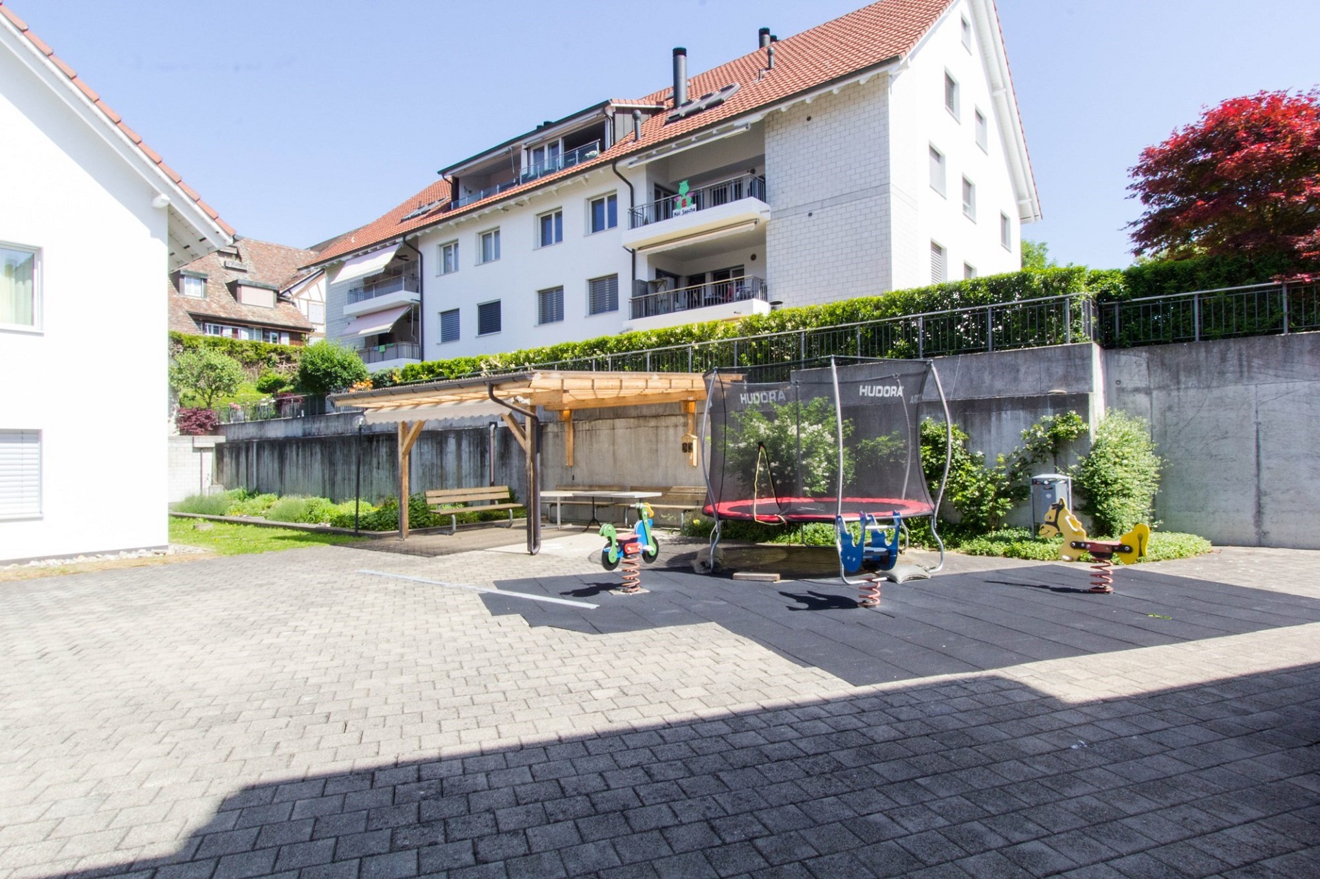 Außenbereich mit Spielplatz und Mehrfamilienhaus