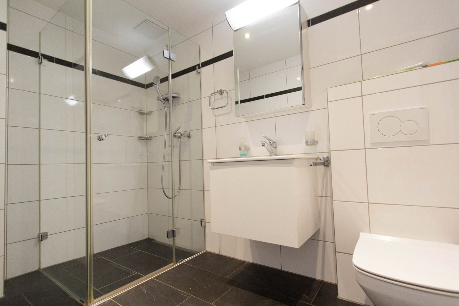 Modernes Badezimmer mit Glasdusche und Wand-WC
