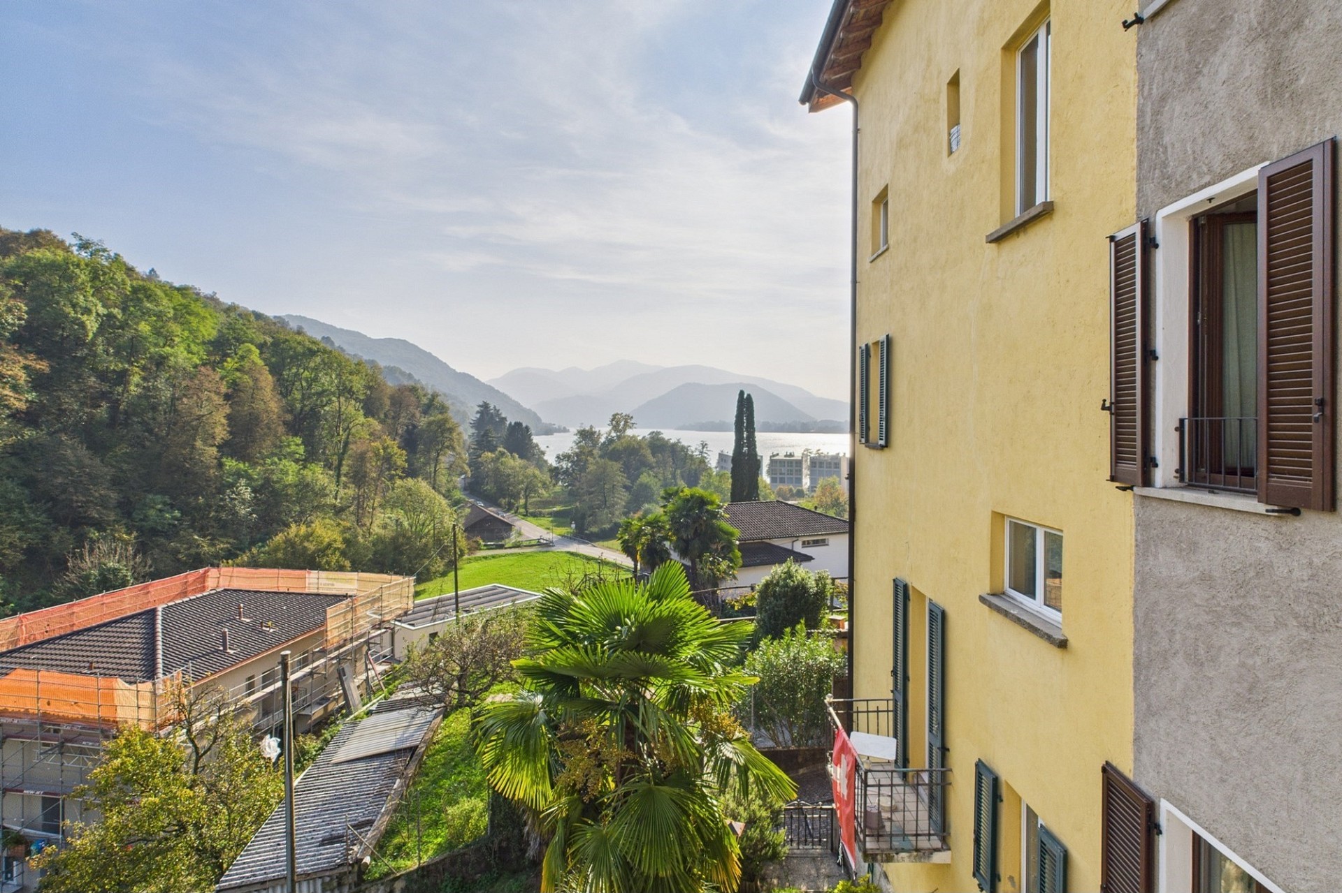 Blick über See und Hügel von einem Wohngebäude