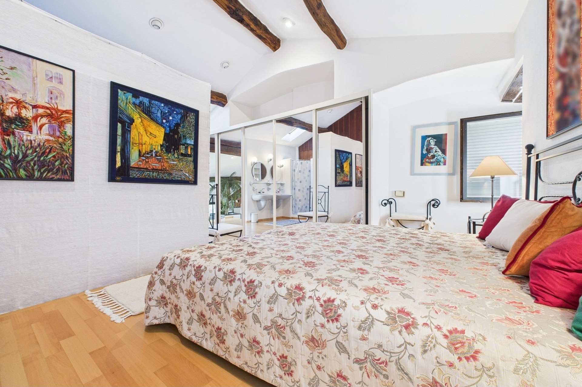 Gemütliches Schlafzimmer mit Dachschrägen und Badbereich im Hintergrund
