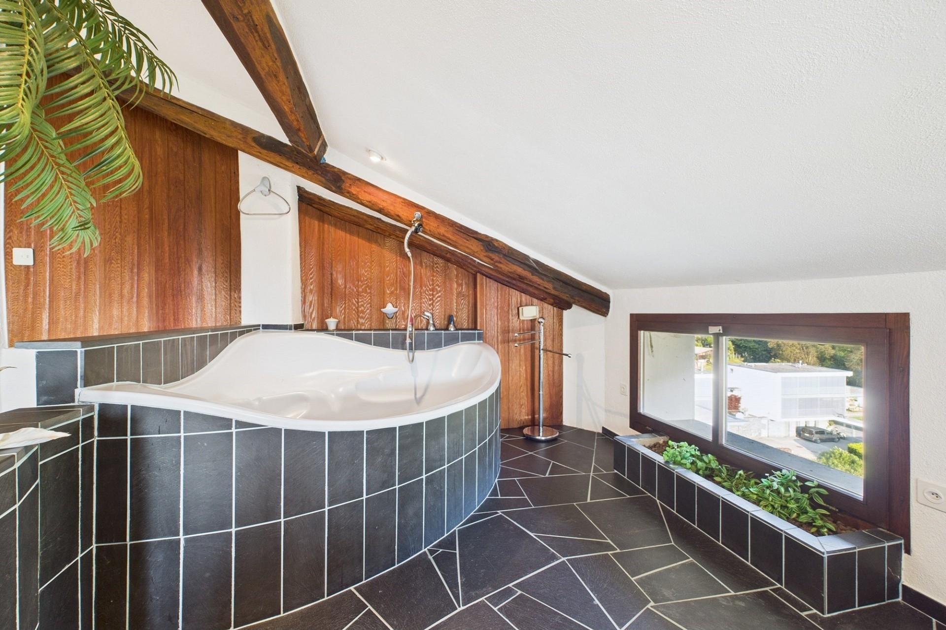 Badezimmer mit eingelassener Wanne und Dachschräge