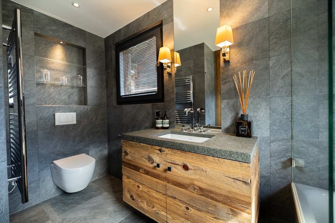 Modernes Badezimmer mit dunklen Fliesen und Holzmöbel