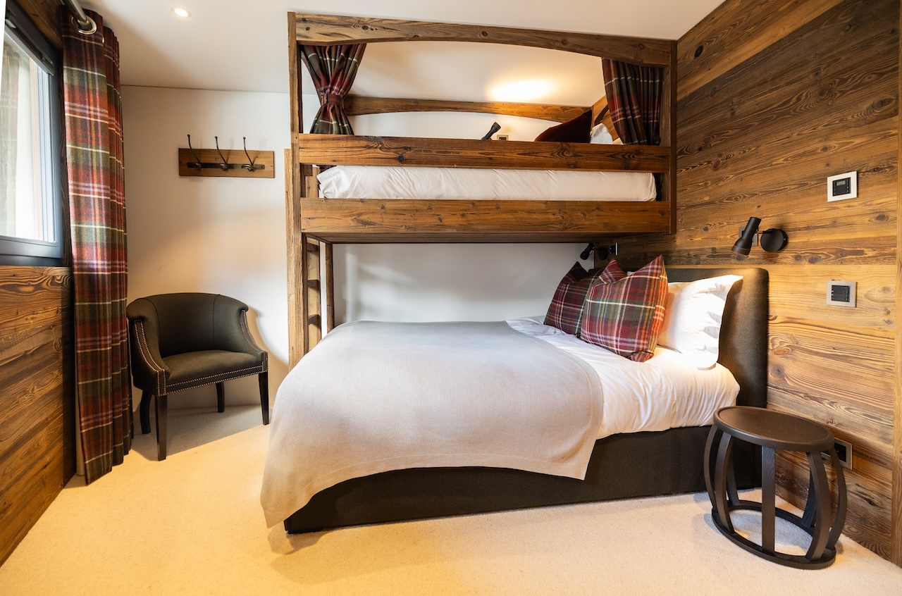Gemütliches Schlafzimmer mit Etagenbett und Holzverkleidung