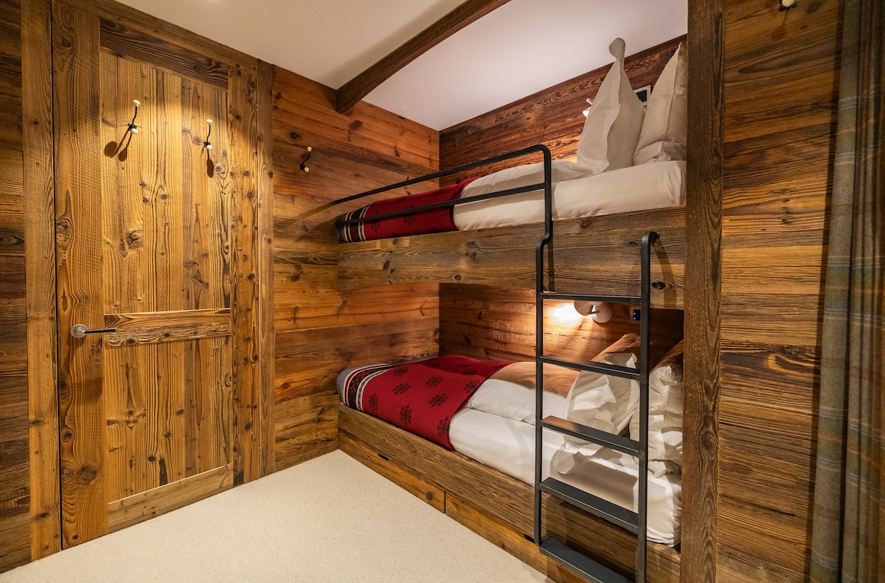 Gemütliches Schlafzimmer mit Etagenbett und Holzverkleidung