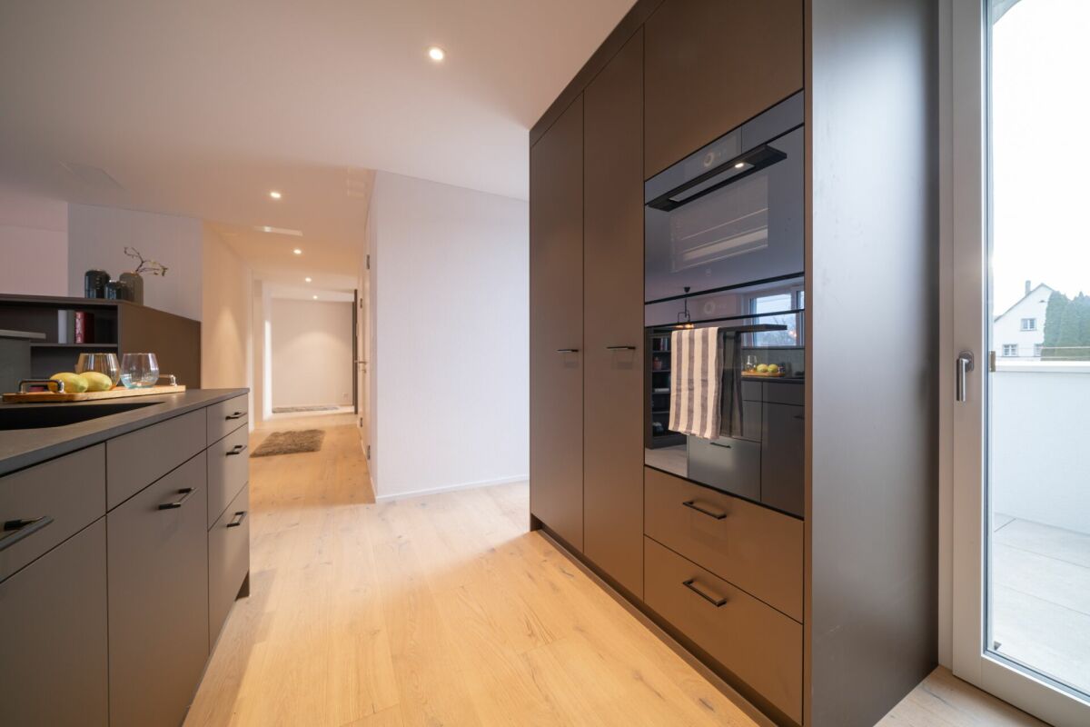 Moderne Küche mit Flur und Zugang zum Balkon