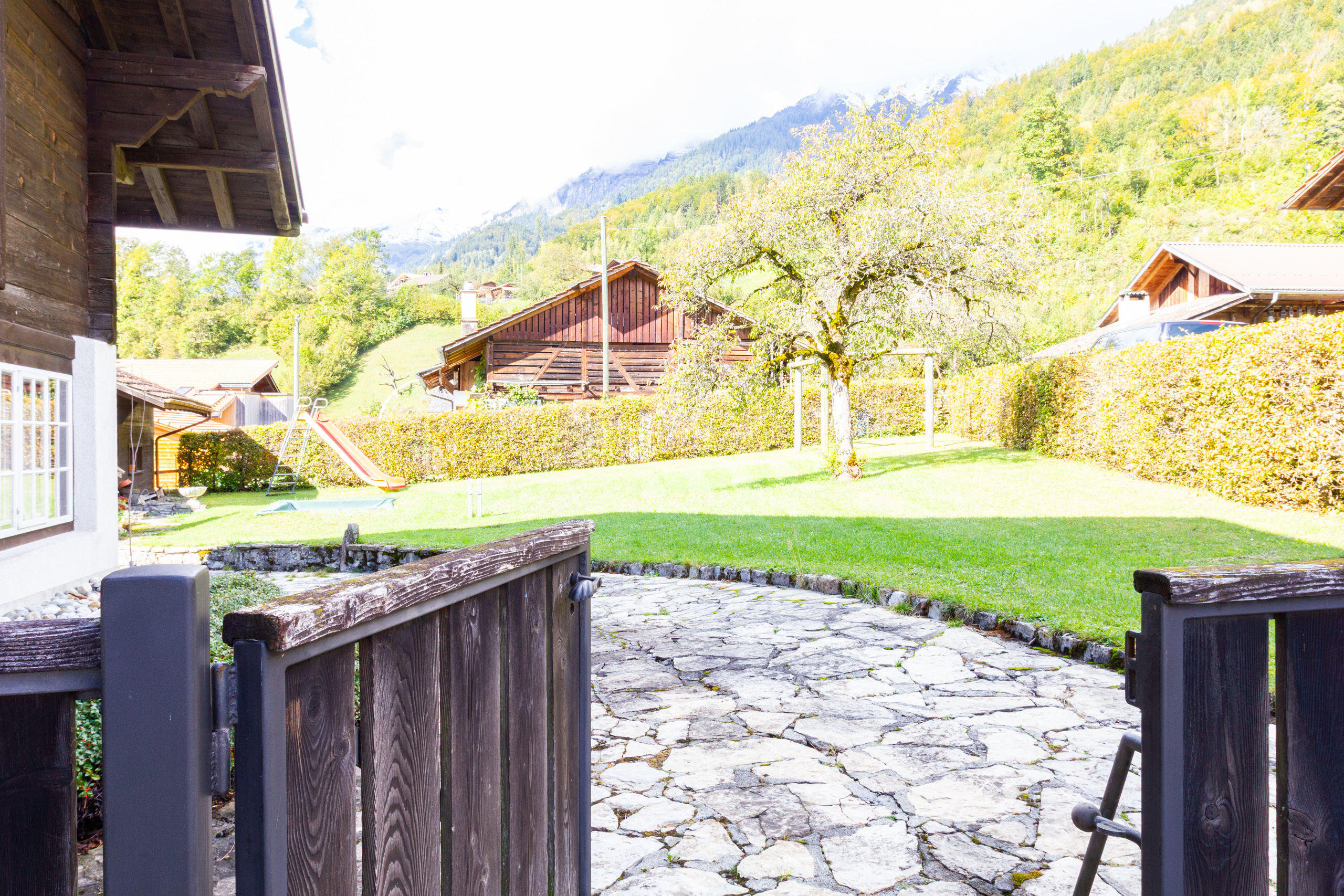 Berggarten mit Holzzaun und Spielbereich