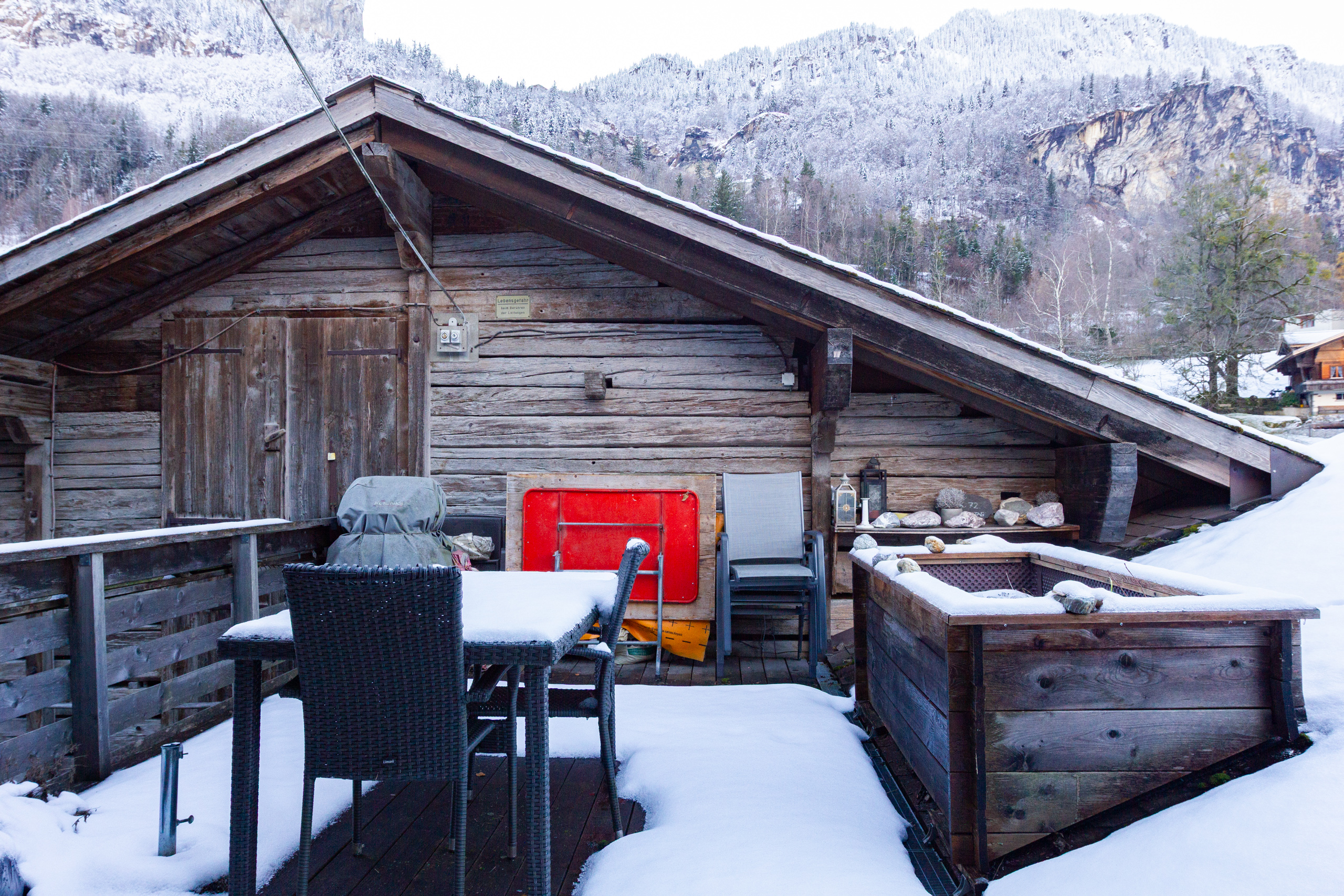 Schneebedeckte Holzterrasse mit Whirlpool