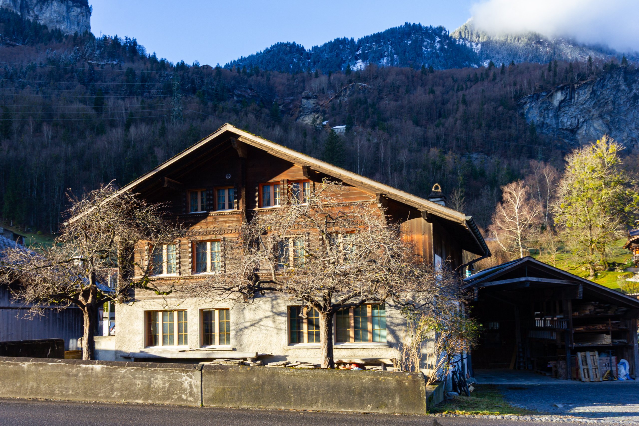 Berghaus mit Holzfassade und Walmdach im Tal