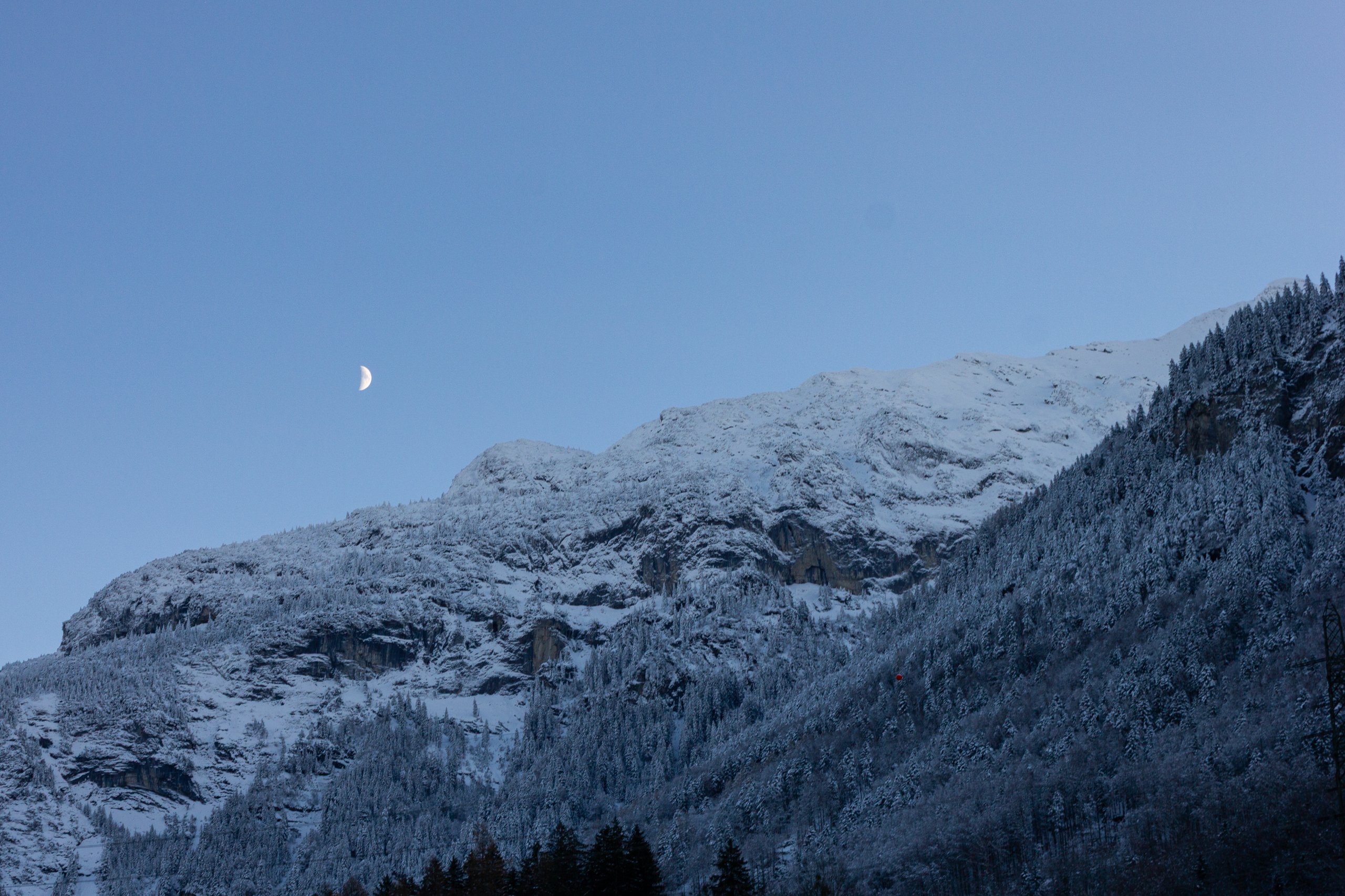 Winterliche Berglandschaft mit zunehmendem Mond