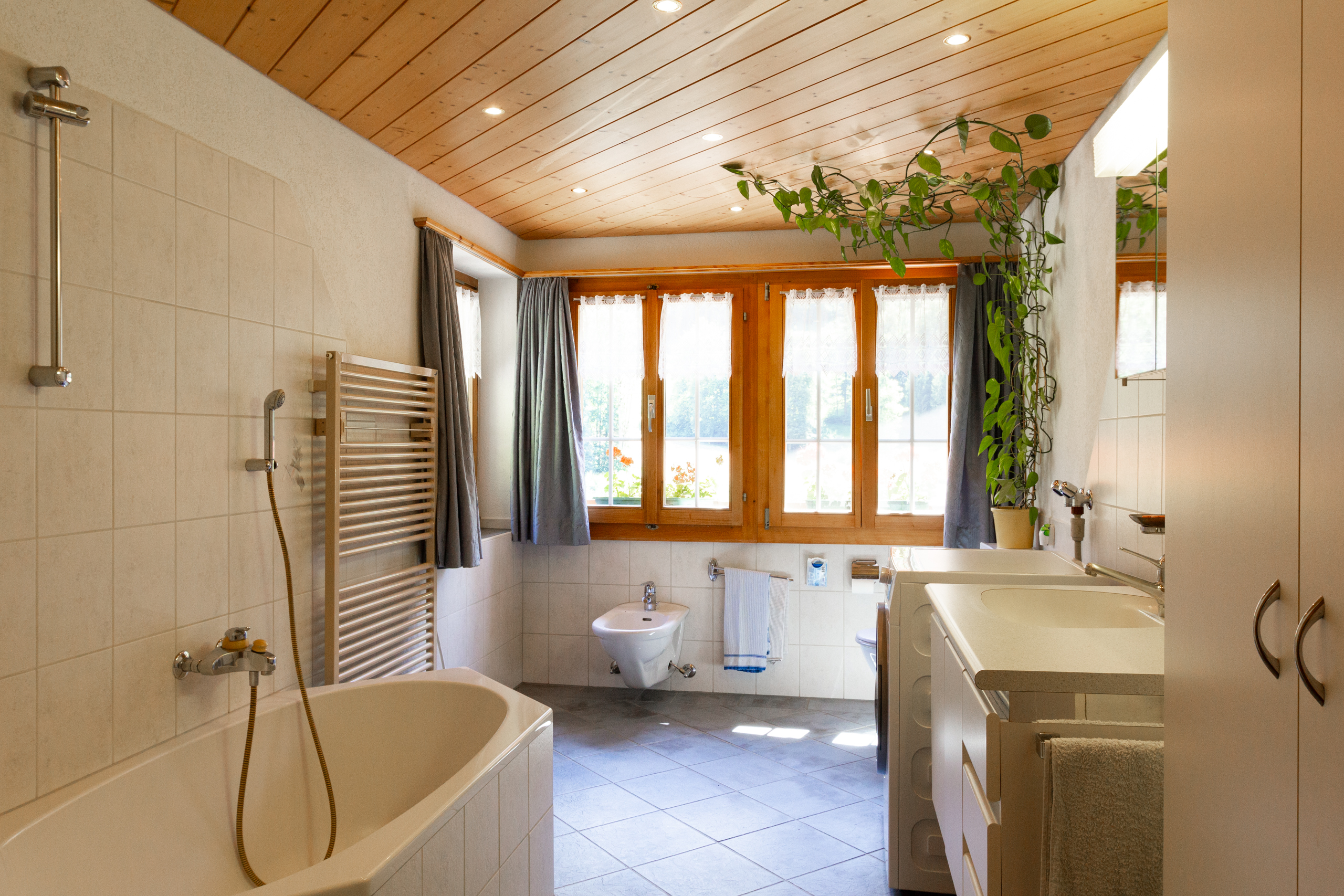 Helles Badezimmer mit Badewanne und Fensterfront