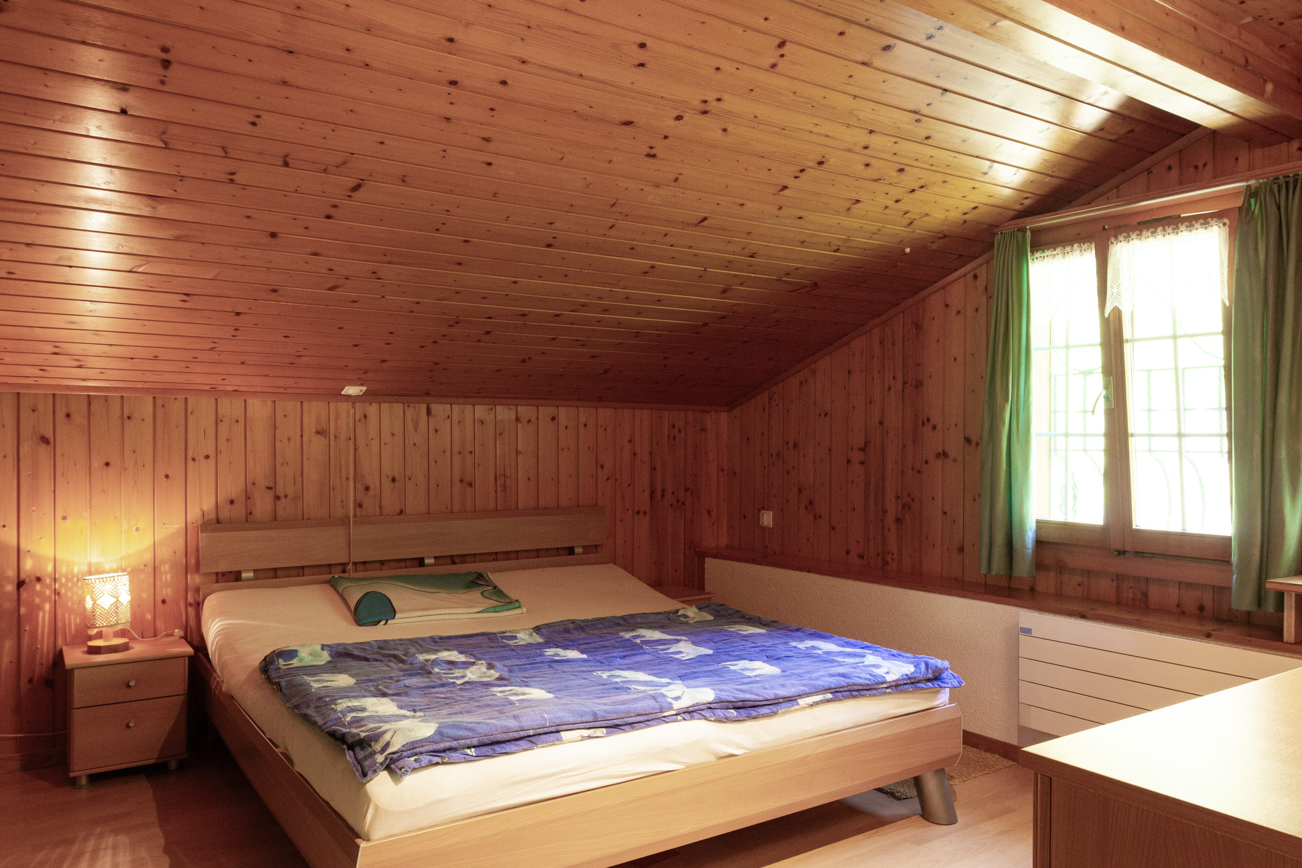 Holzverkleidetes Schlafzimmer mit Dachschräge
