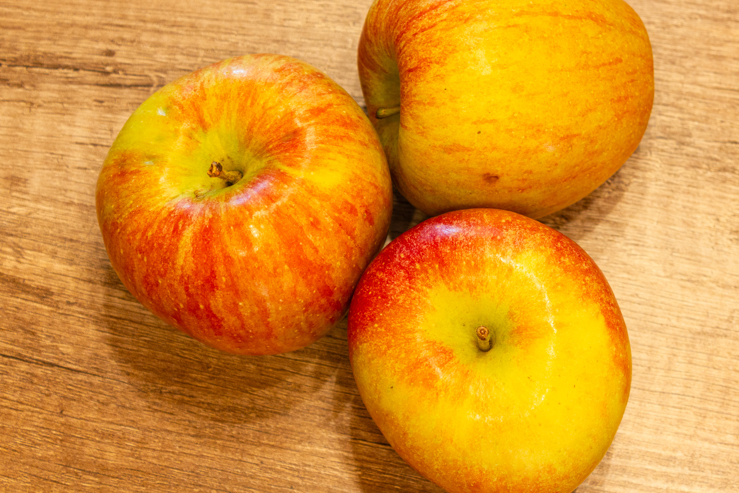Drei Äpfel auf einer Holzoberfläche