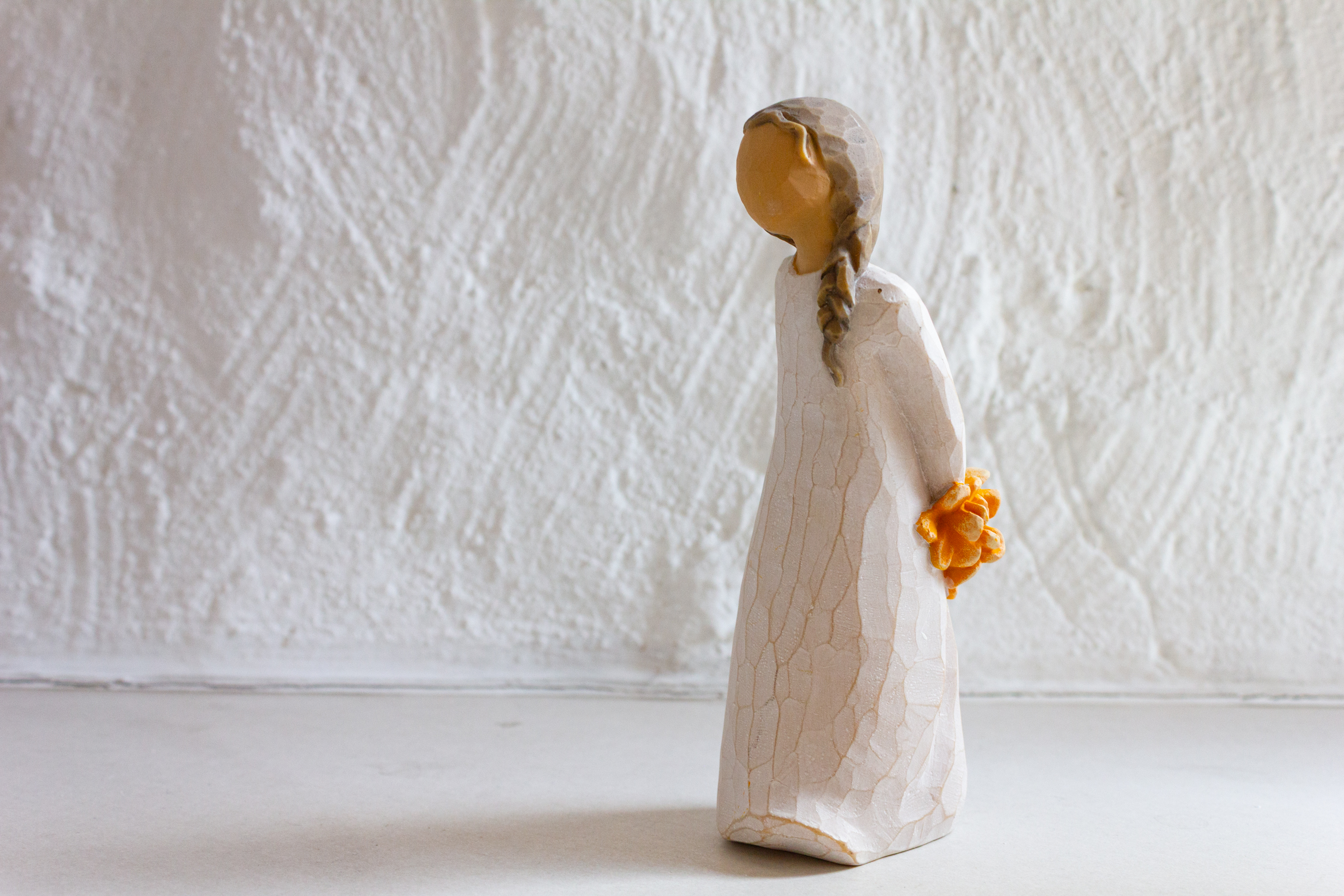 Dekorative Holzfigur vor strukturierter Wand