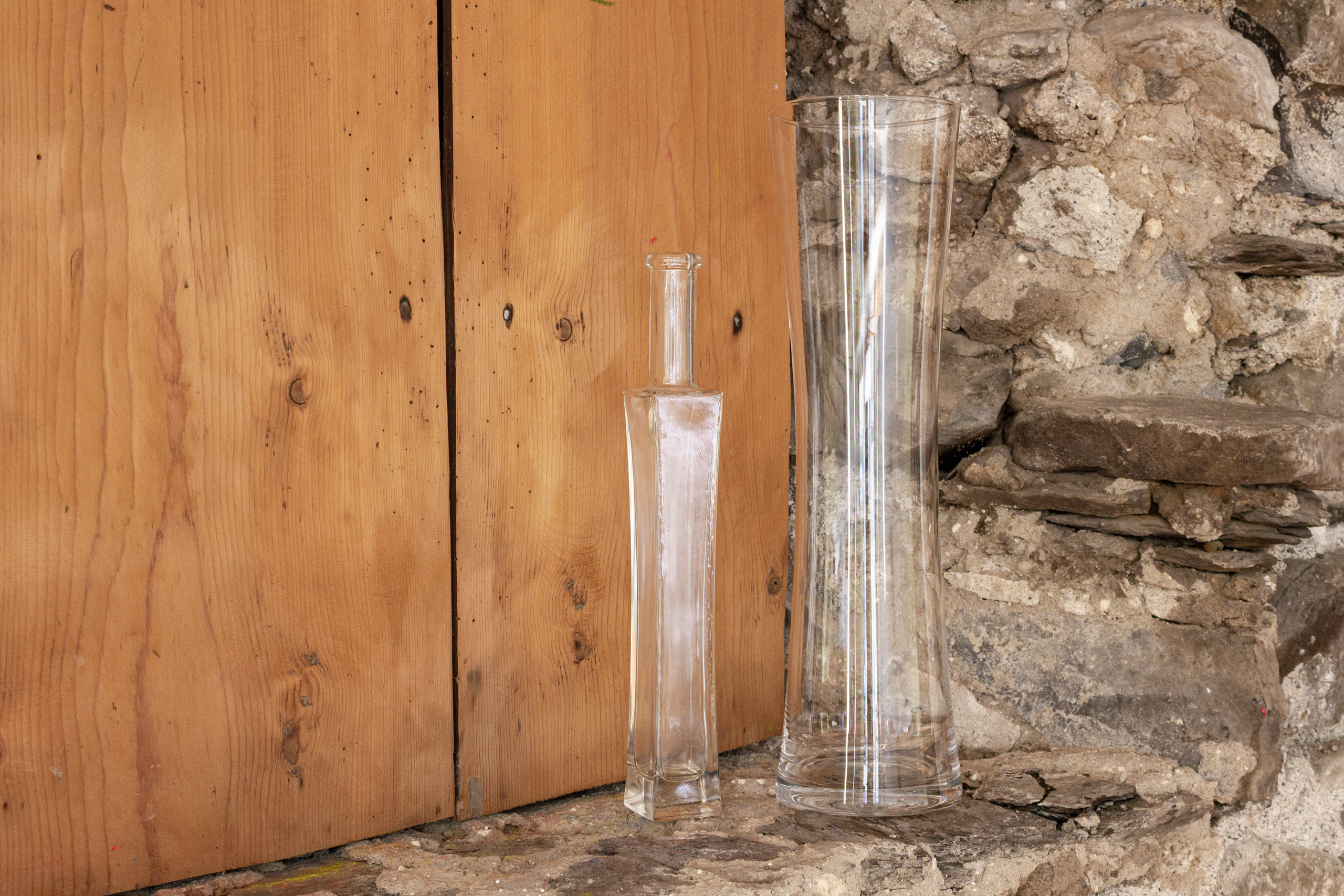 Rustikale Stein- und Holzdetails mit Glasvasen