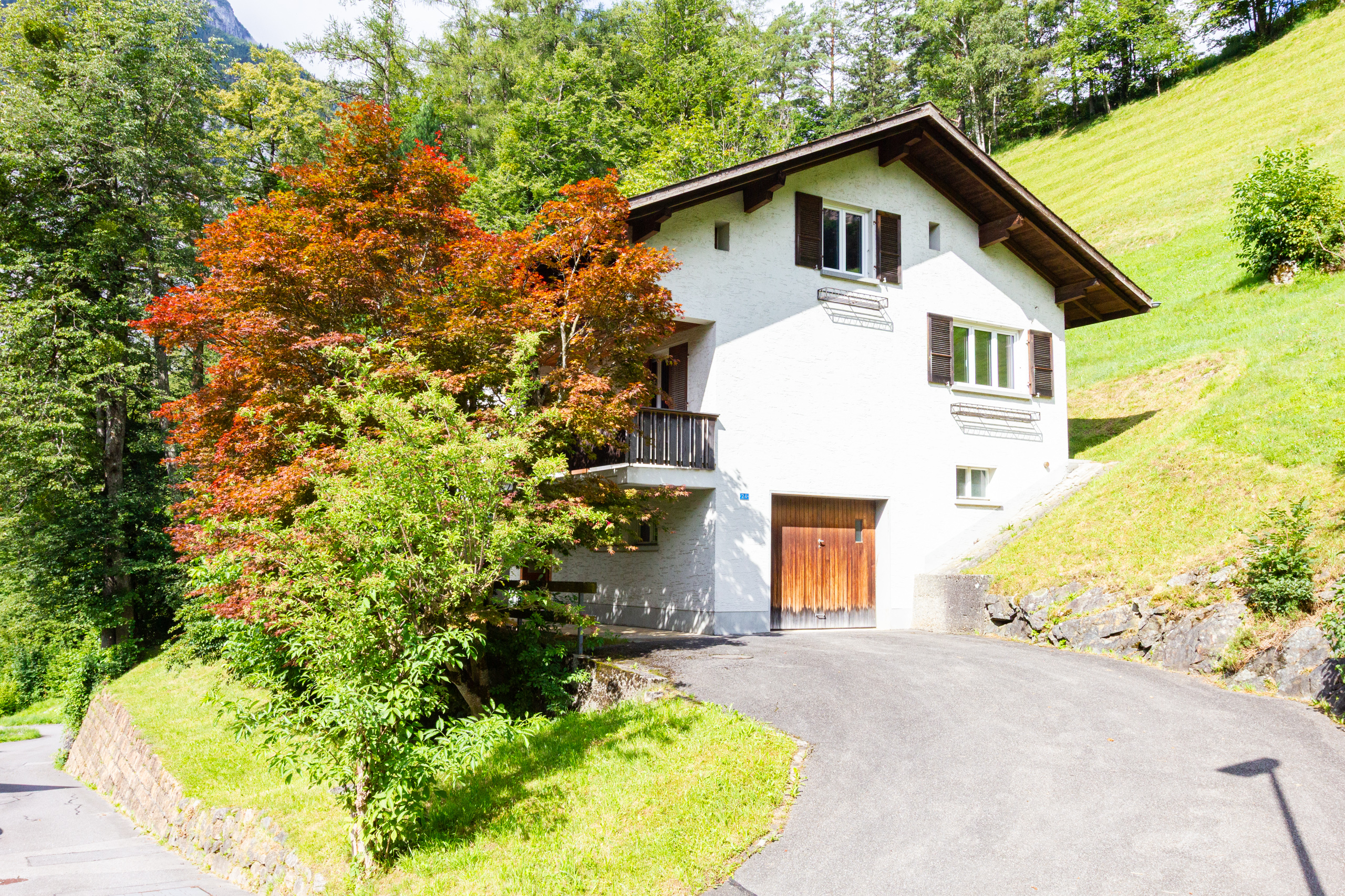 Berghaus mit weißer Fassade und Satteldach