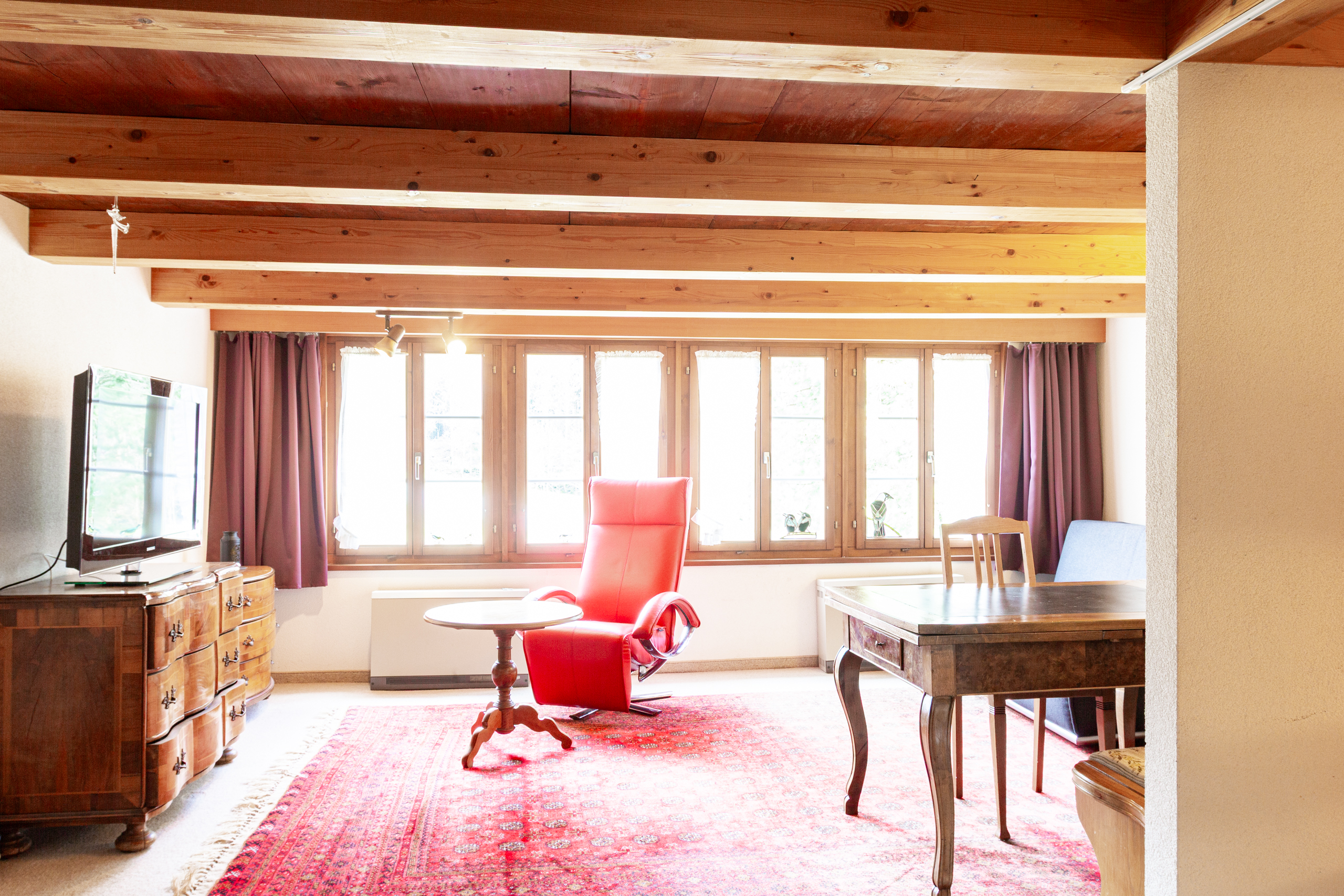 Wohnzimmer mit Holzdecke und großen Fenstern