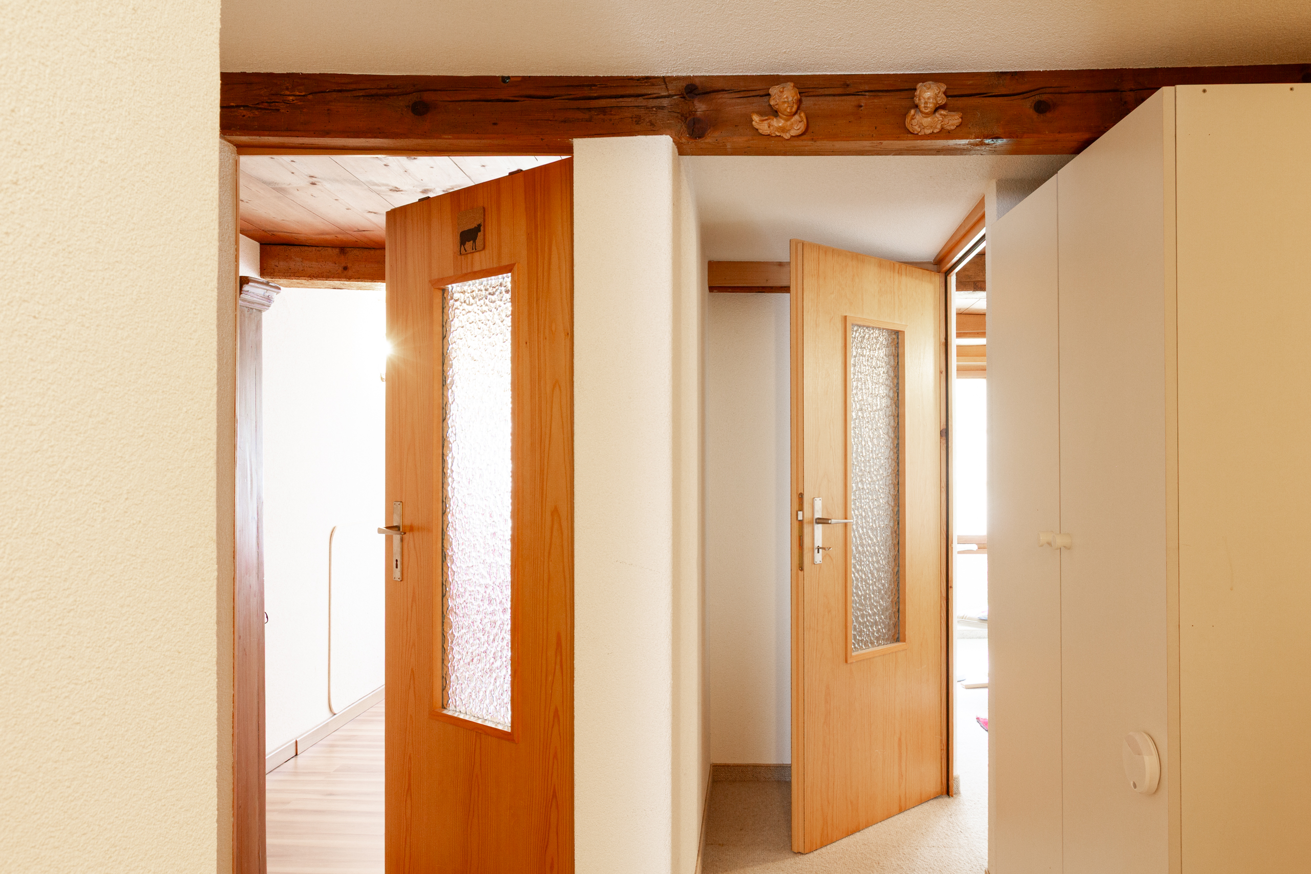 Flur mit Holztüren und sichtbaren Deckenbalken