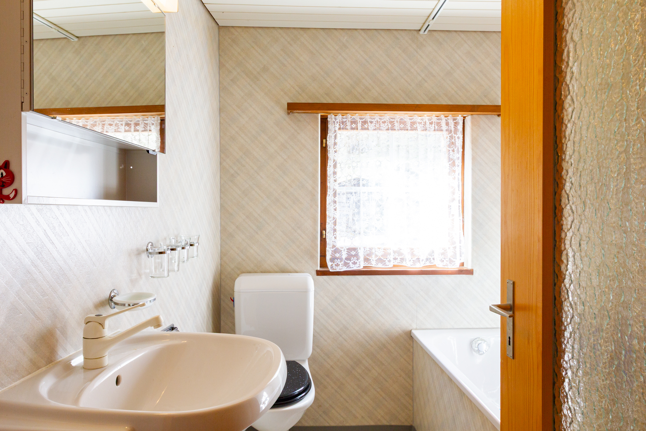 Kleines Badezimmer mit Badewanne und Fenster
