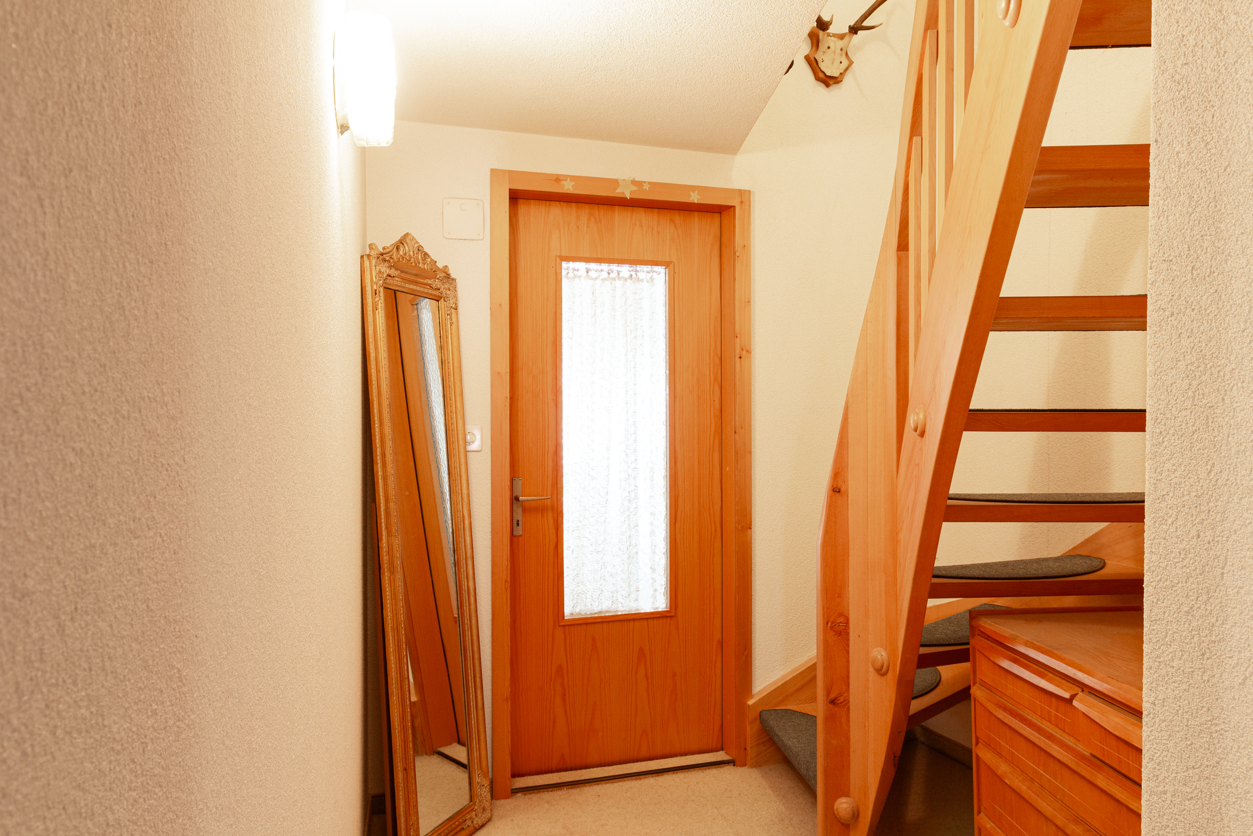 Heller Flur mit Holztreppe