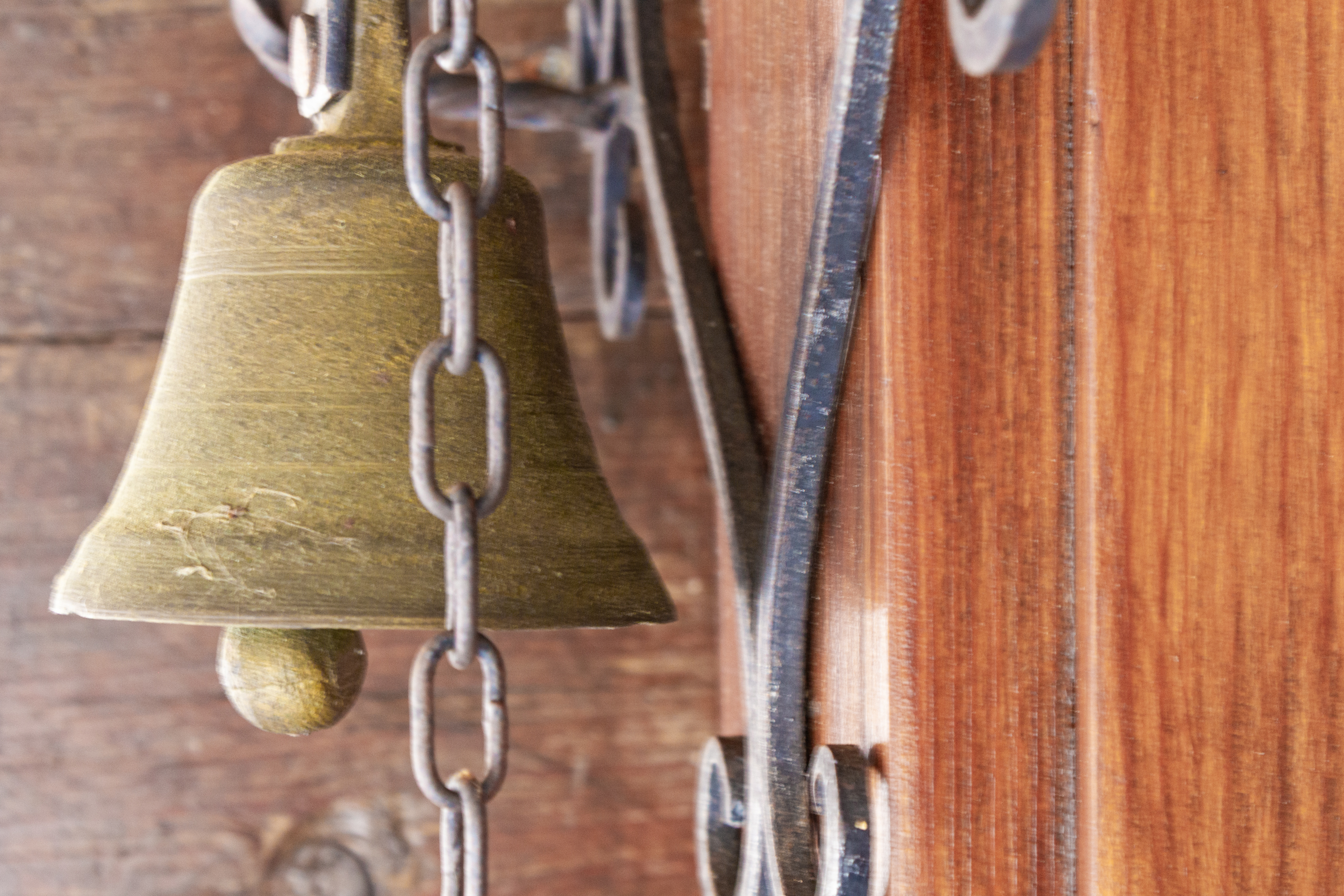 Nahaufnahme einer Messingglocke an einer Holzkonstruktion