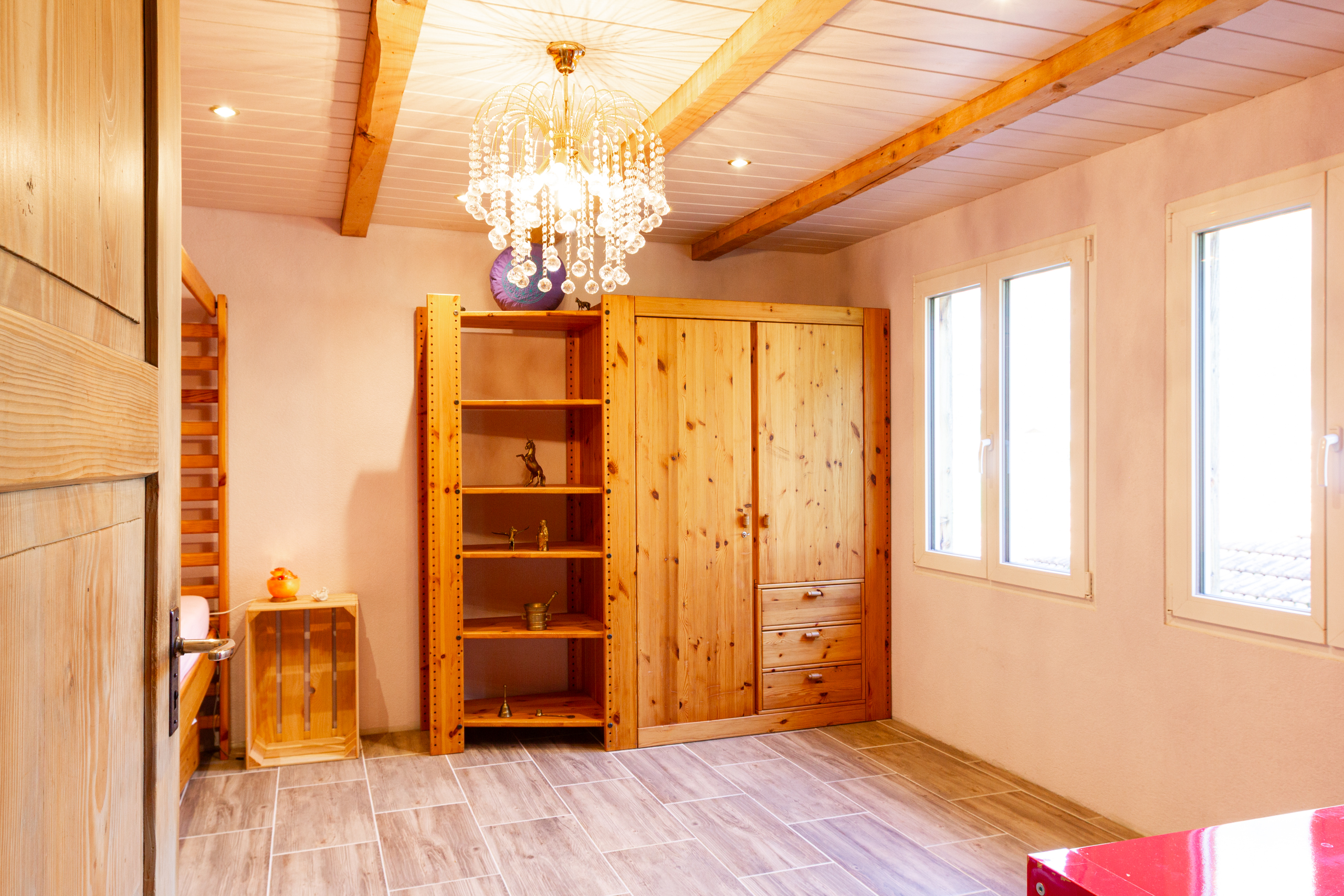 Heller Raum mit Holzschrank und Kronleuchter