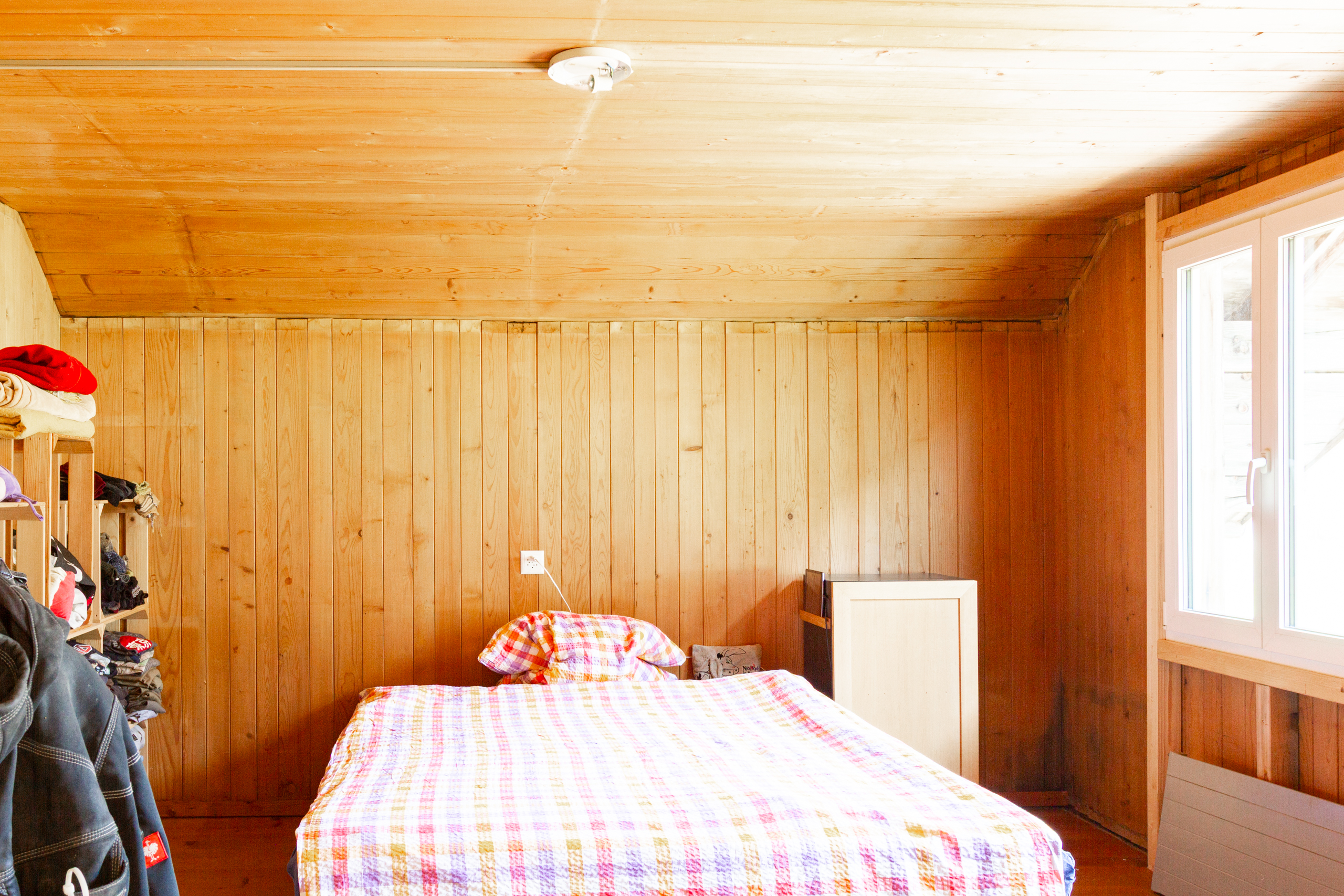 Holzverkleidetes Schlafzimmer mit Dachschräge