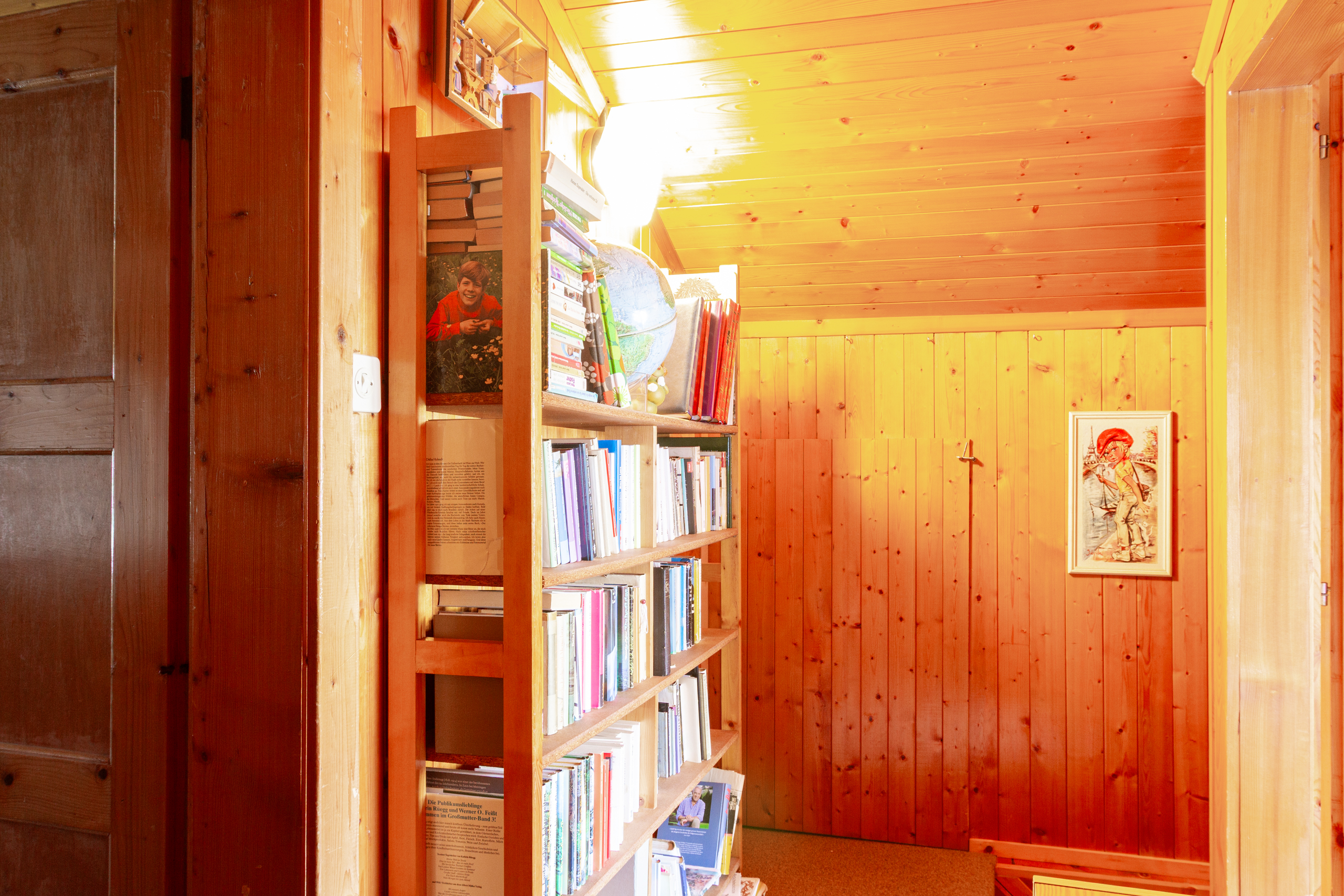 Dachgeschossflur mit Holzvertäfelung und Bücherregal