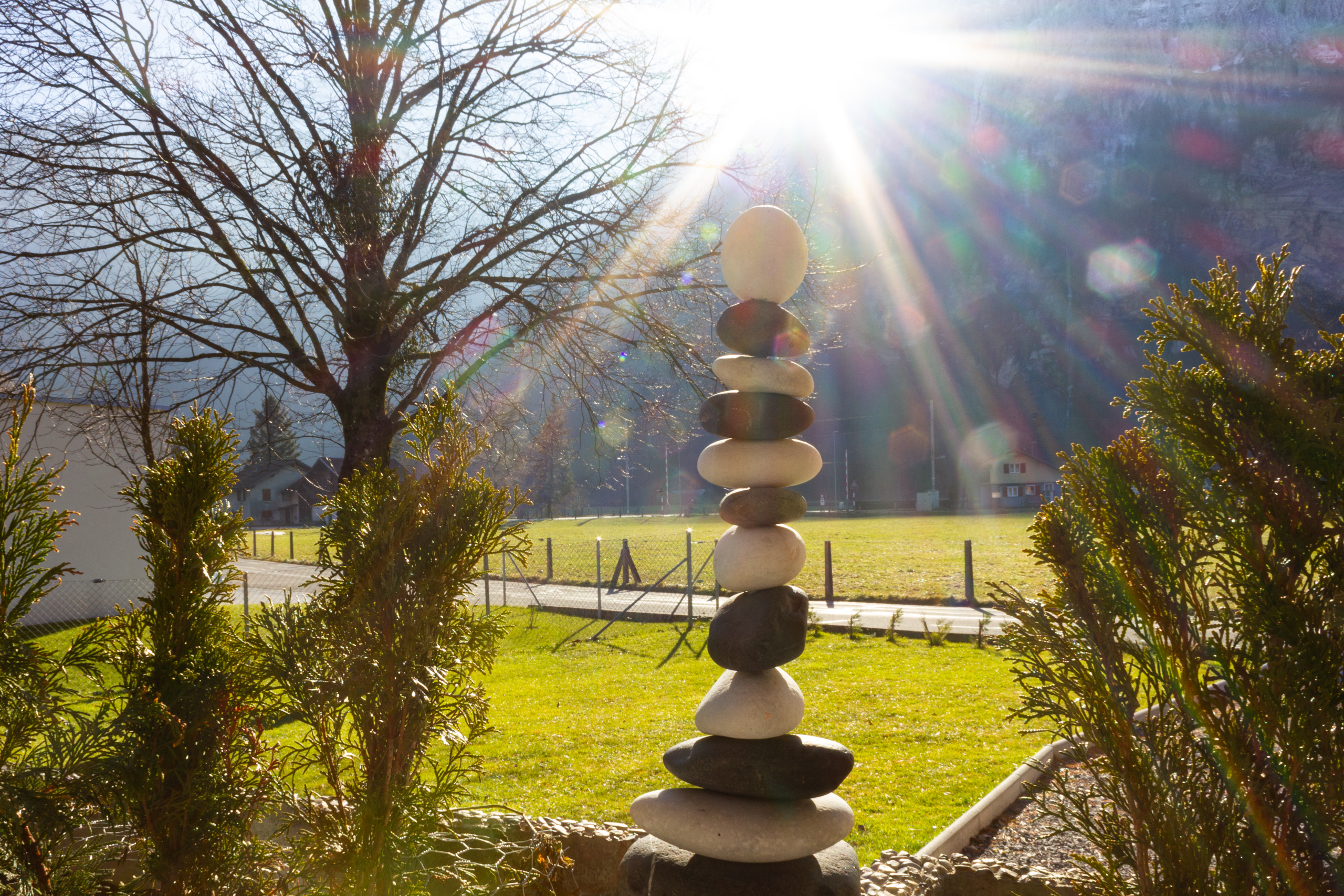 Garten mit Steinskulptur im Sonnenlicht