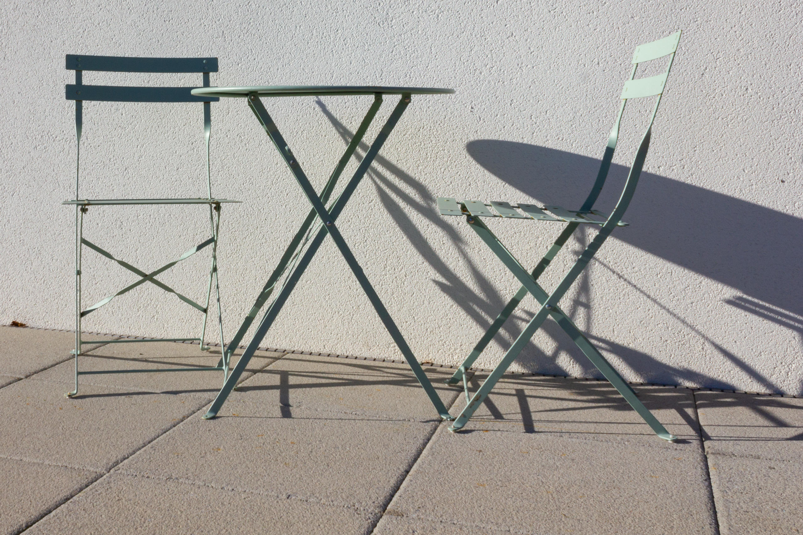 Gartenmöbel auf Terrasse vor heller Wand