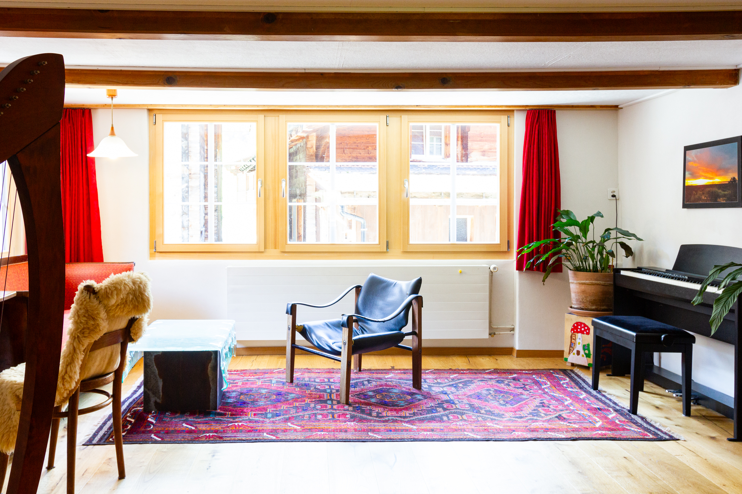 Heller Wohnraum mit Klavier und Stühlen