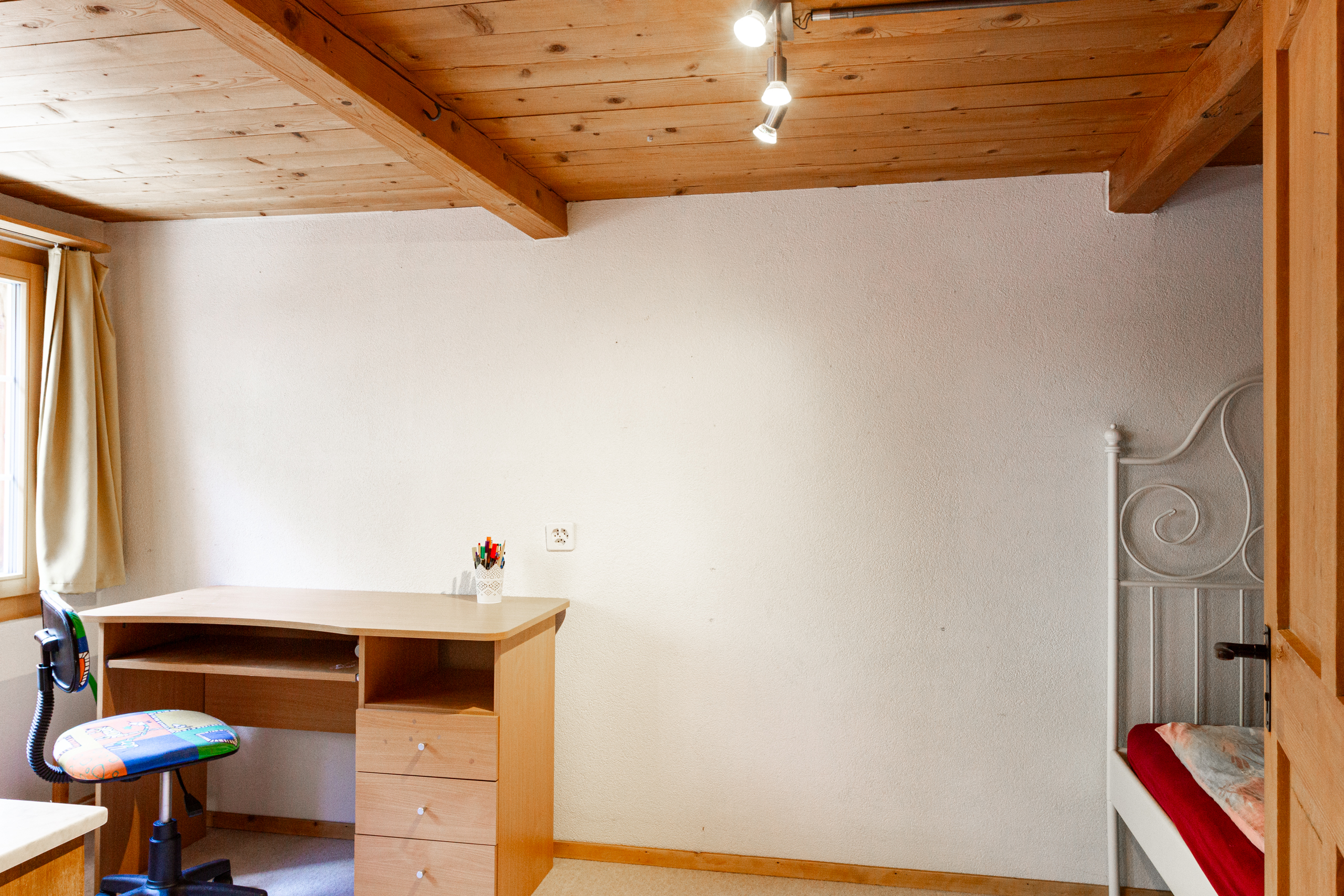 Kleines Schlafzimmer mit Holzbalkendecke