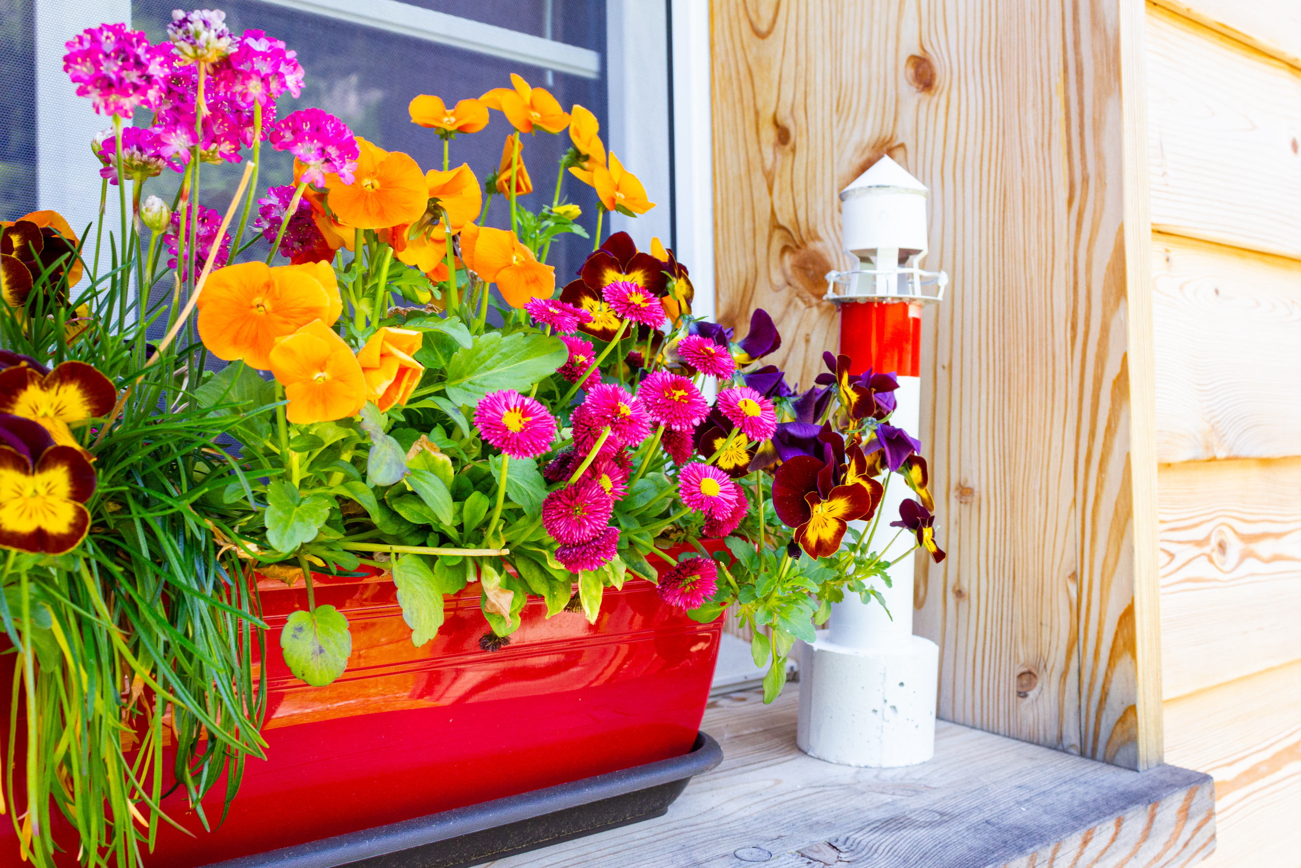 Blumenarrangement auf einer Holzveranda