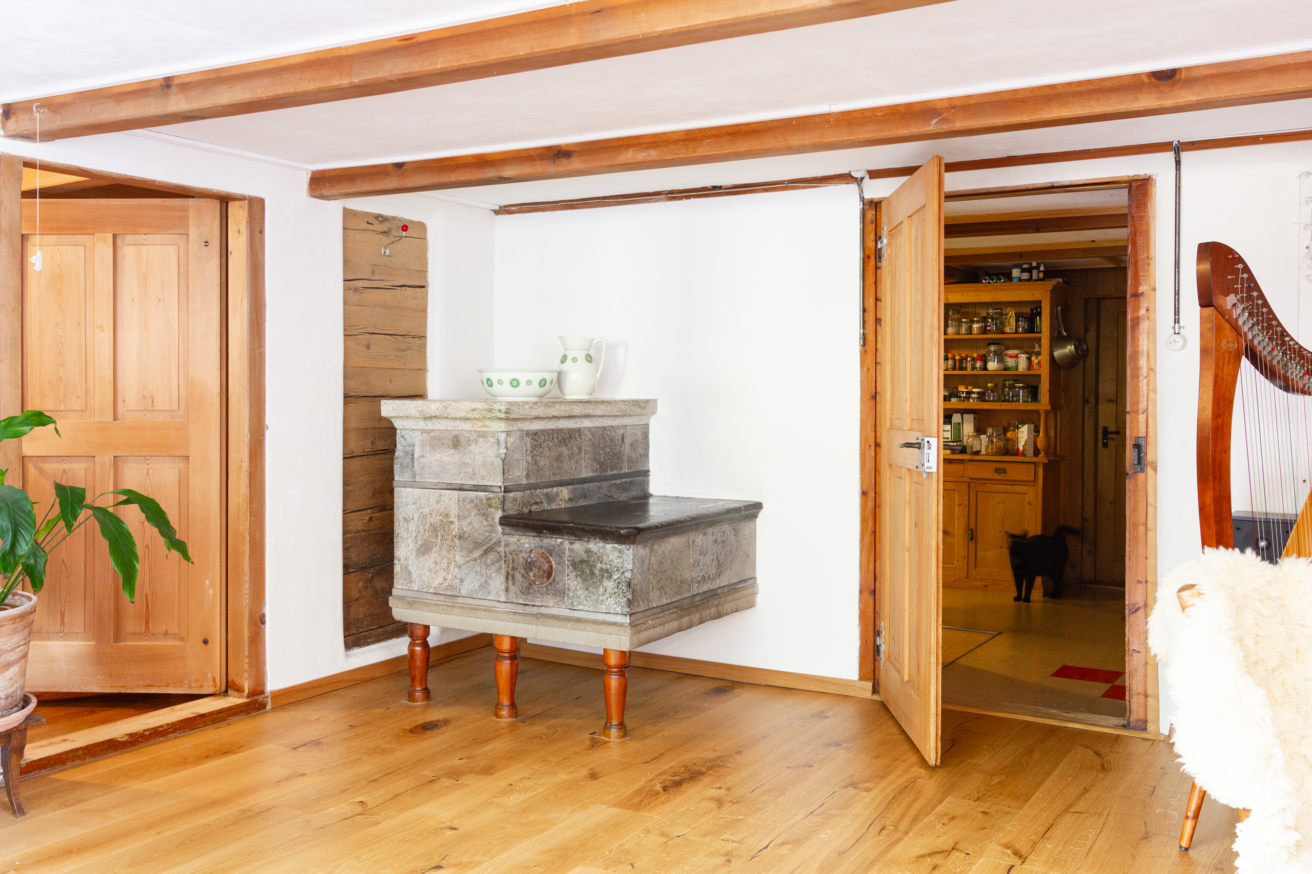 Gemütlicher Raum mit Holzbalken und Kaminofen